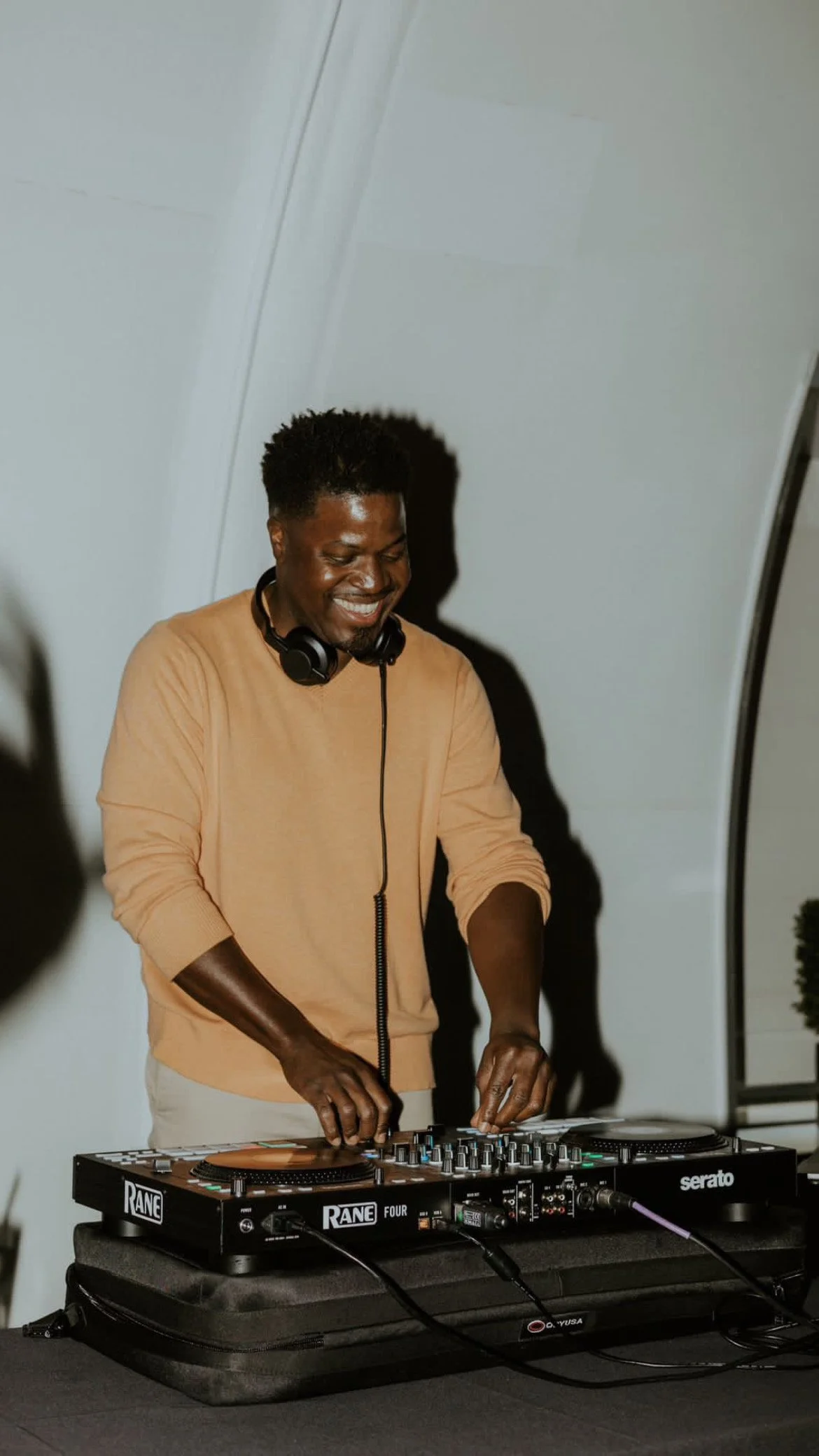DJ Ness, Elliott Harris, mixing behind the decks at a Milwaukee wedding reception