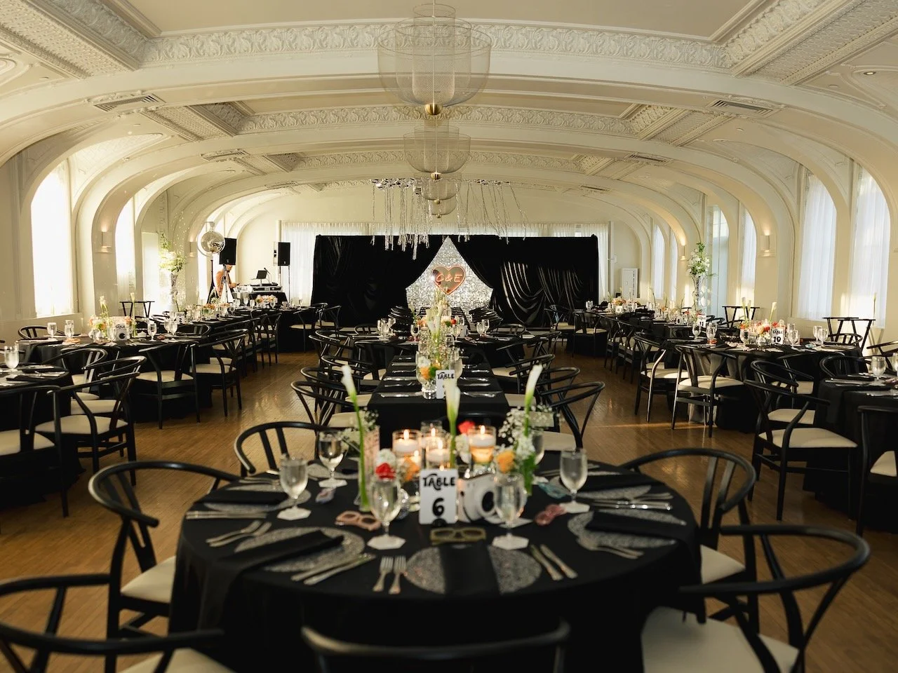 Image filled with tables and chairs inside Hotel Cottonwood's rentable ballroom set for a wedding dinner