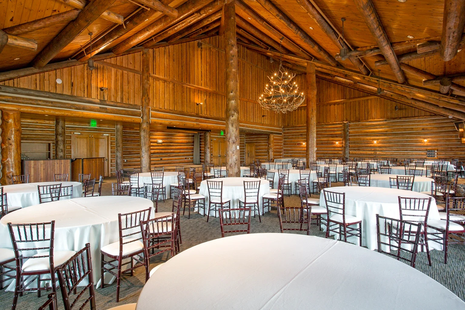 Wood cabin room with tall ceilings and tables and chairs