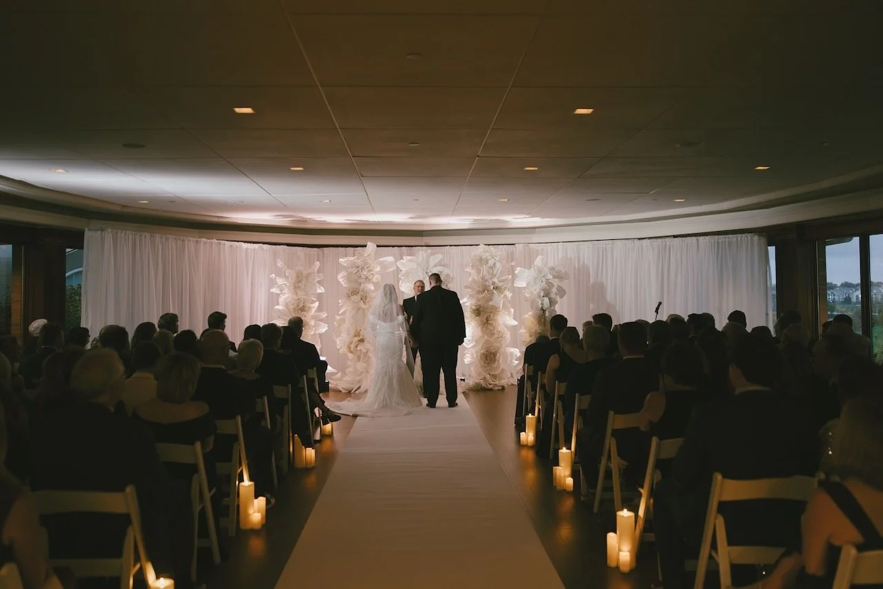 Room filled with people sitting watching a wedding ceremoy in an Omaha golf club
