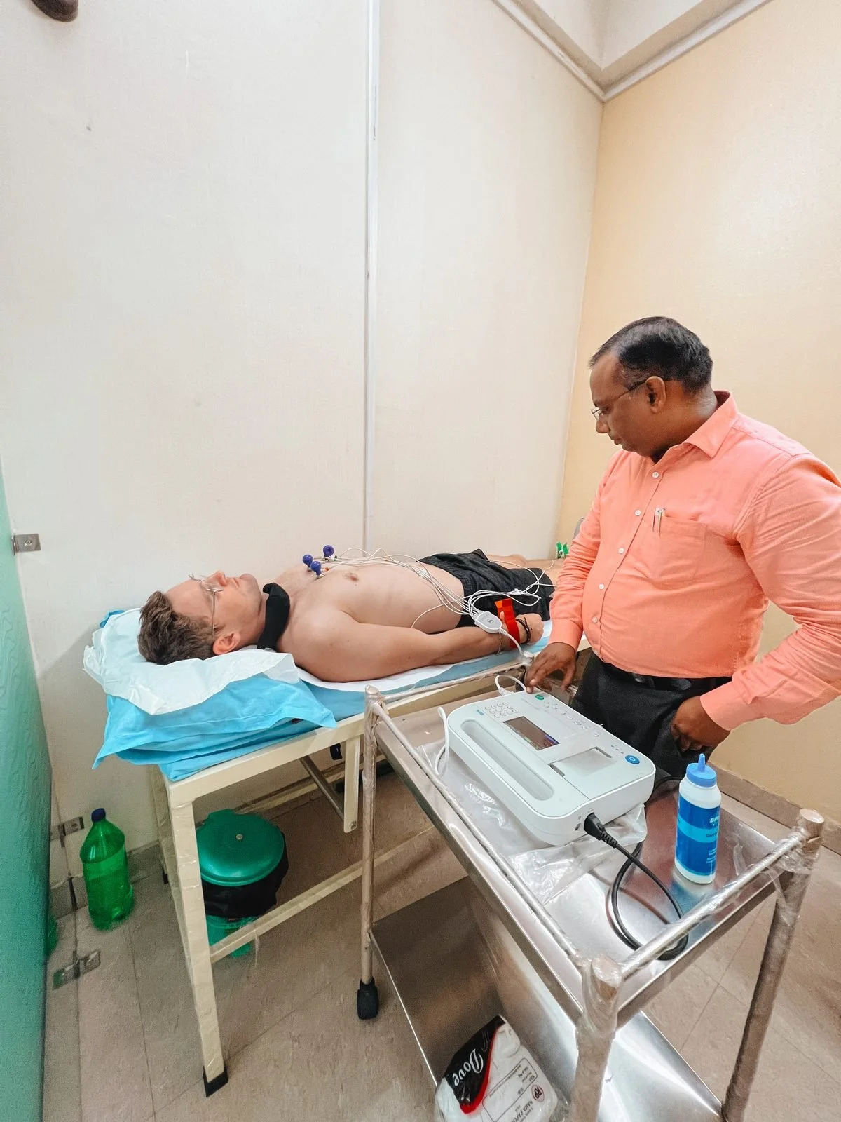 Rhett having an ECG at a clinic abroad, a doctor visit covered by travel insurance