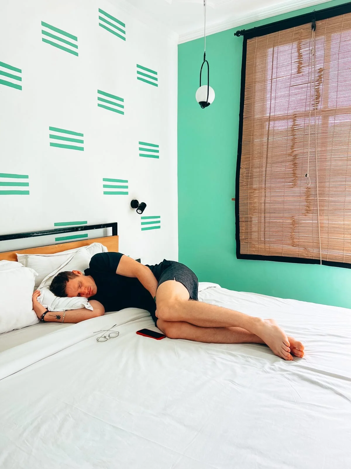 Rhett sick in bed in a hotel room while travelling
