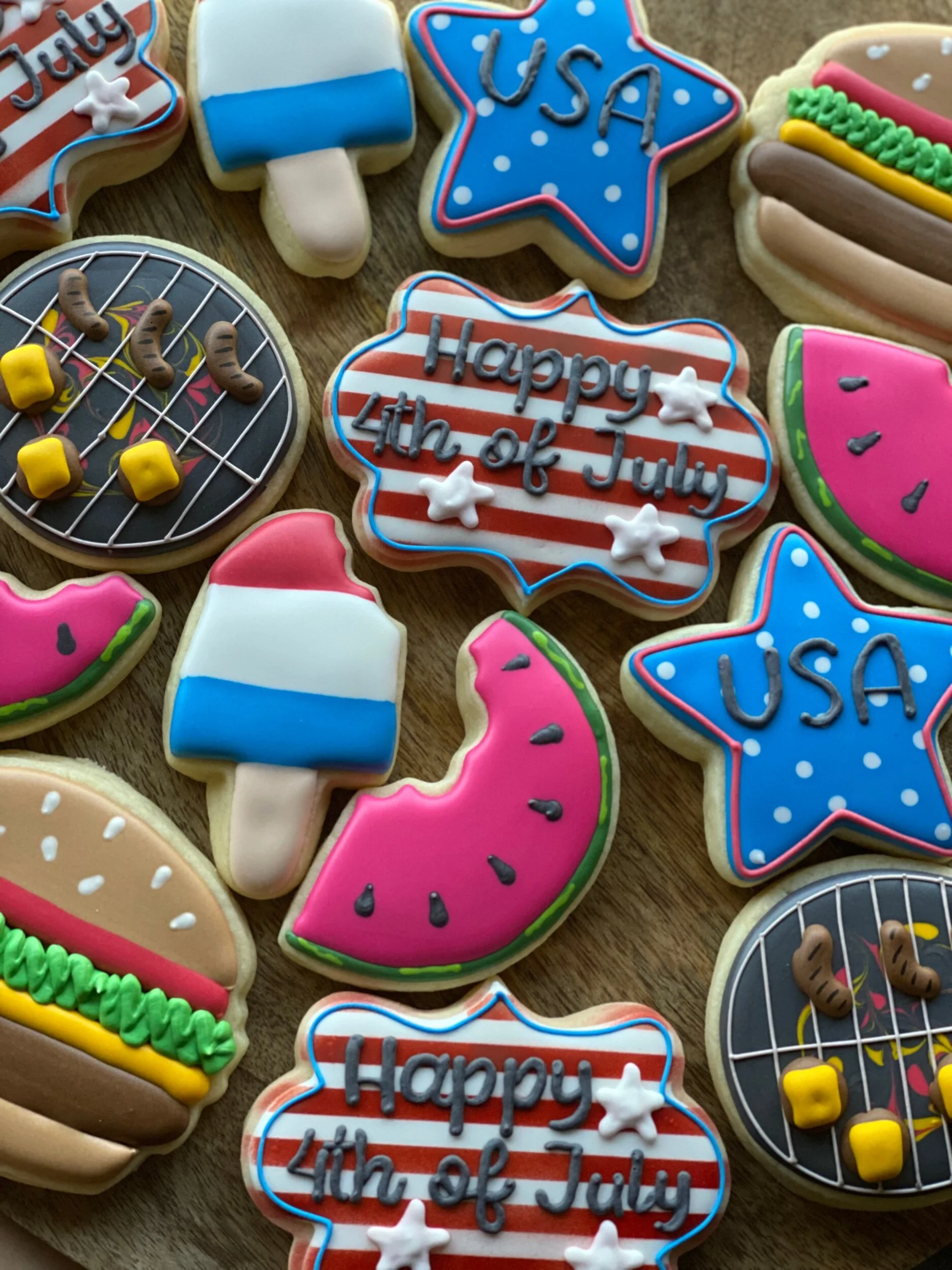 Decorated cookies with American-themed and Fourth of July designs, including stars, stripes, and patriotic messages.