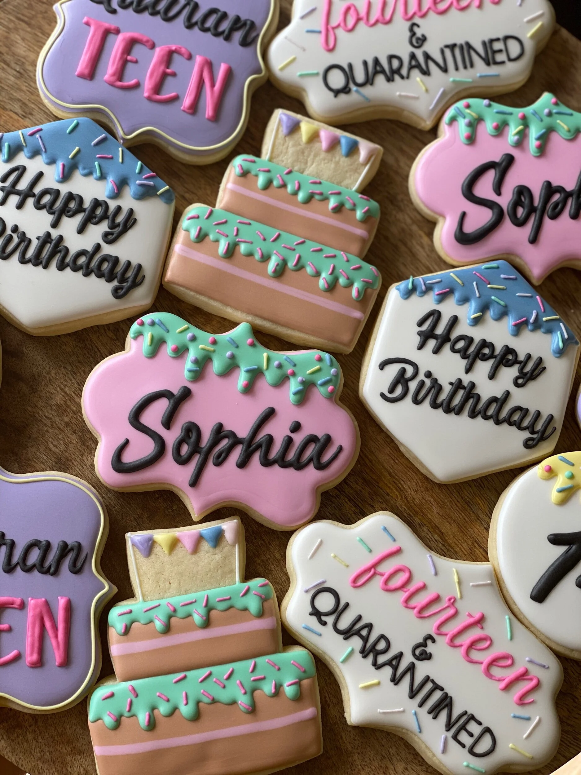 Decorated cookies with birthday and quarantine themes, in pastel colors, with messages like 'Happy Birthday,' 'Sophie,' 'treat,' and 'quarantined' on them.