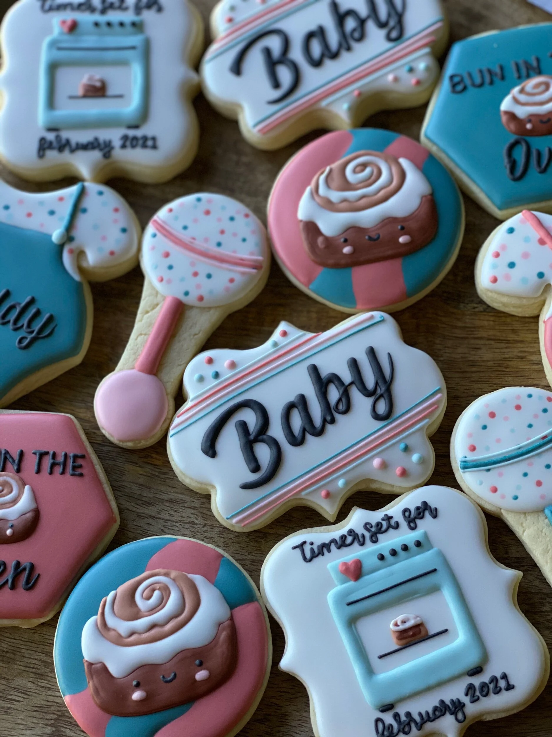 Decorated cookies with baking and birthday themes, featuring words like 'Baking' and 'Happy', and images of cupcakes, a whisk, and a mixer, in pastel pink, blue, and white colors.