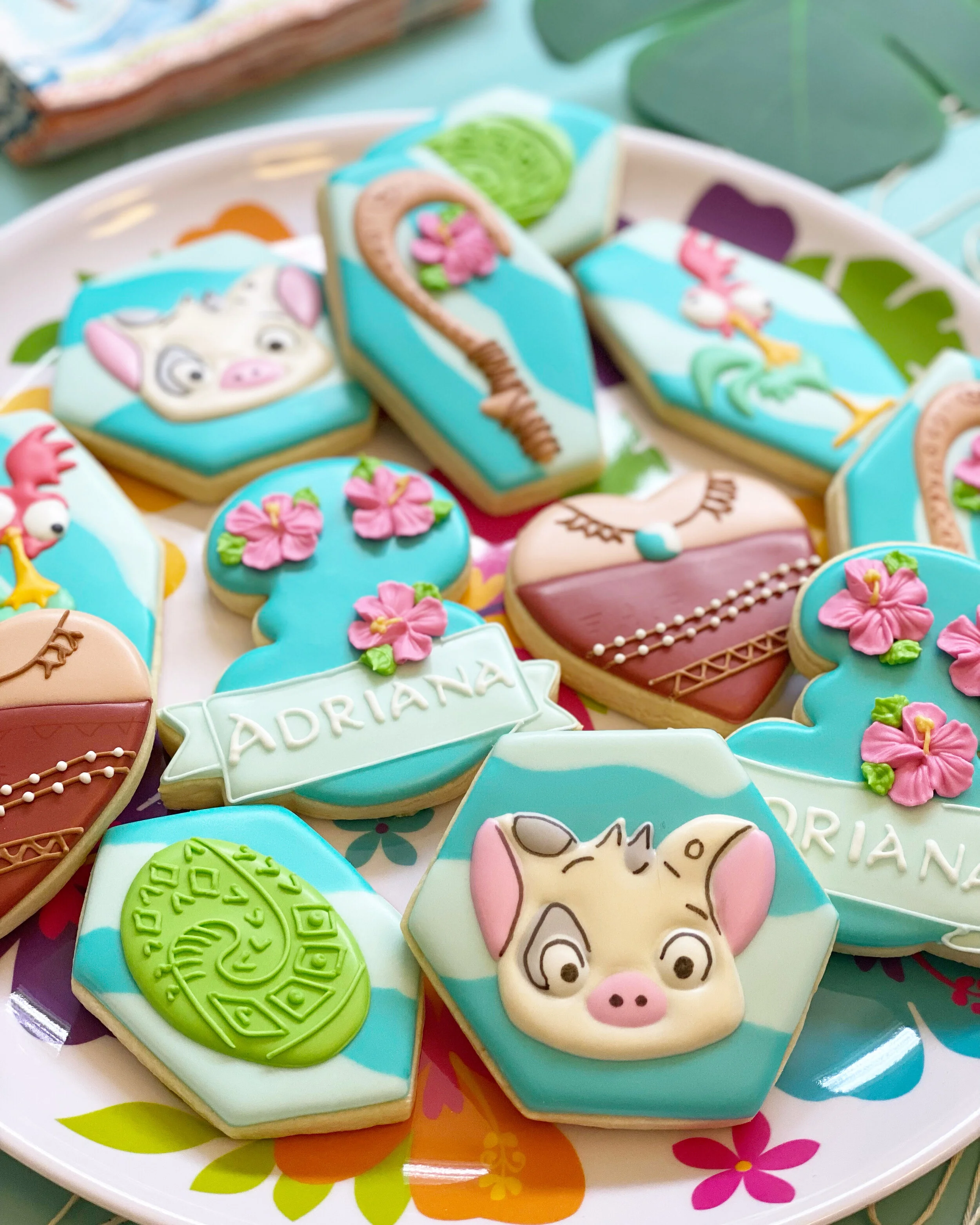 Decorated cookies with various animal and floral designs on a colorful plate.
