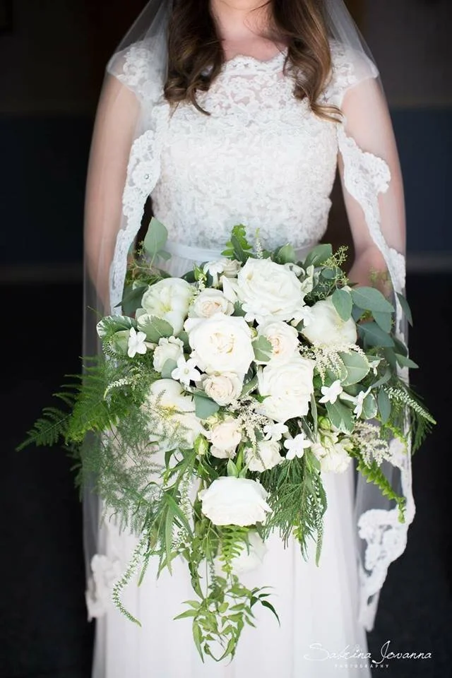 cascading bridal bouquet made of white roses, white astilbe, eucalyptus, and plumosa, sonora florist