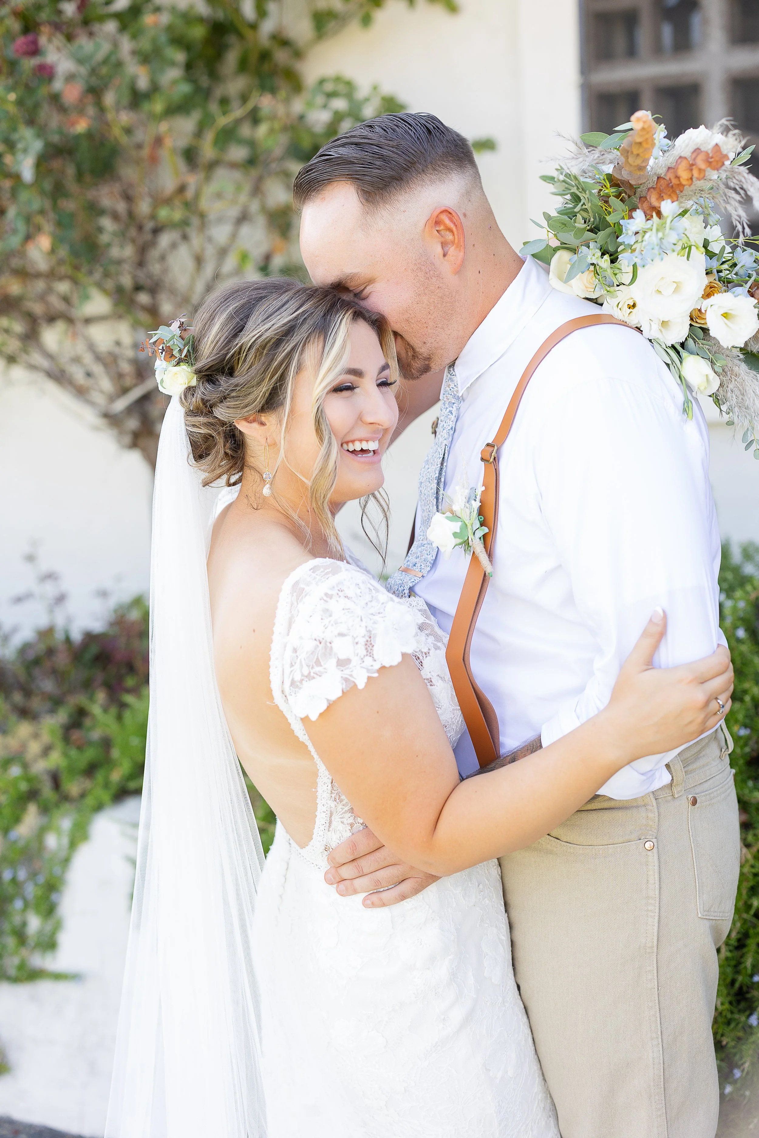 bride smiling while groom whsipers in her ear while she holds her bouquet, tuolumne county