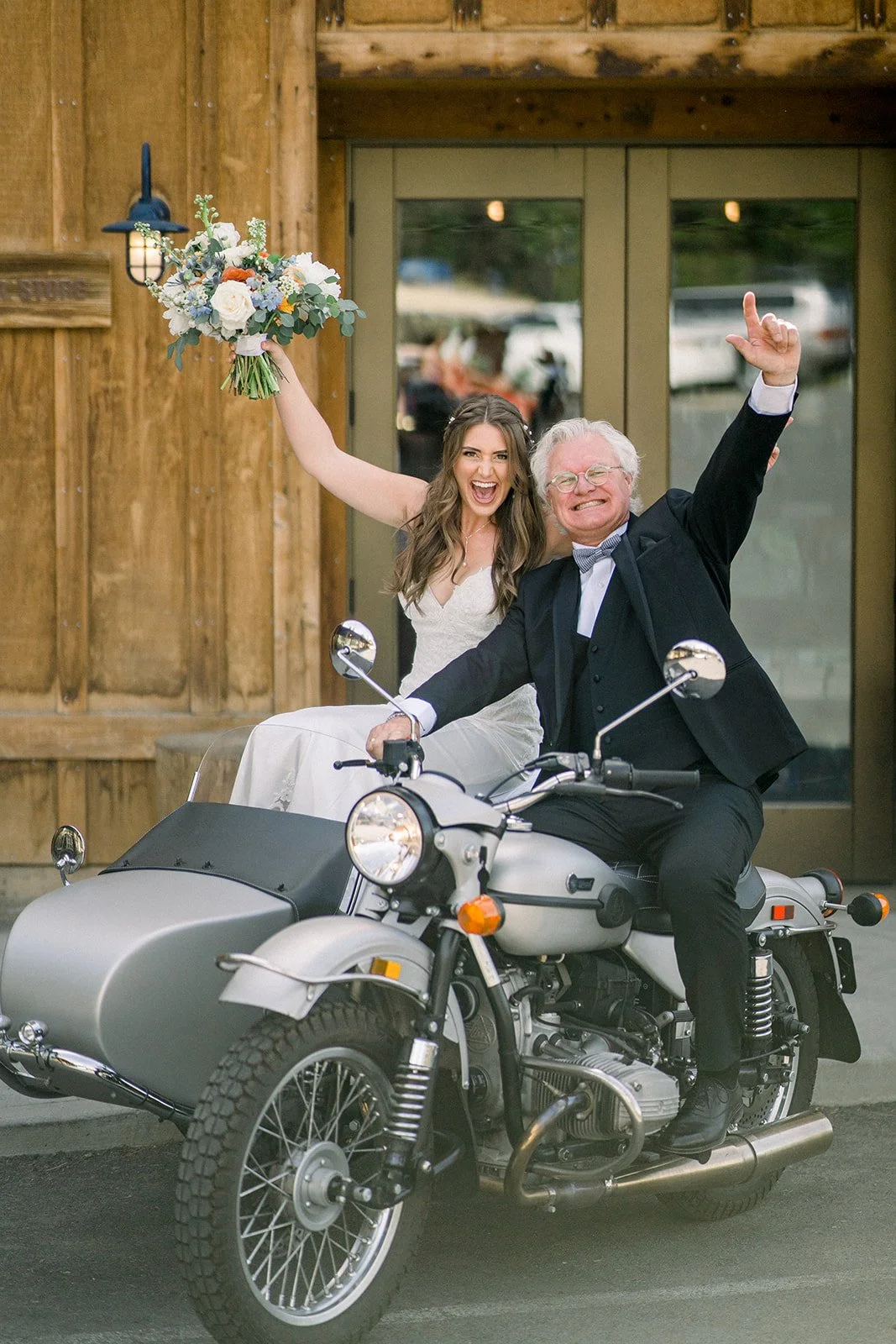 Bride and her father riding into wedding on a bike holding her flowers in the air, groveland ca