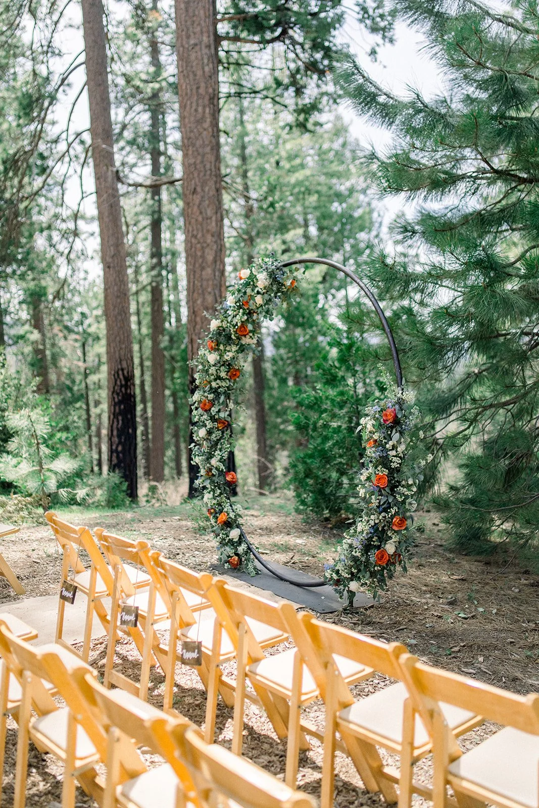 Round arch with flower on it in the colors orange, blue, and white, rushcreek lodge
