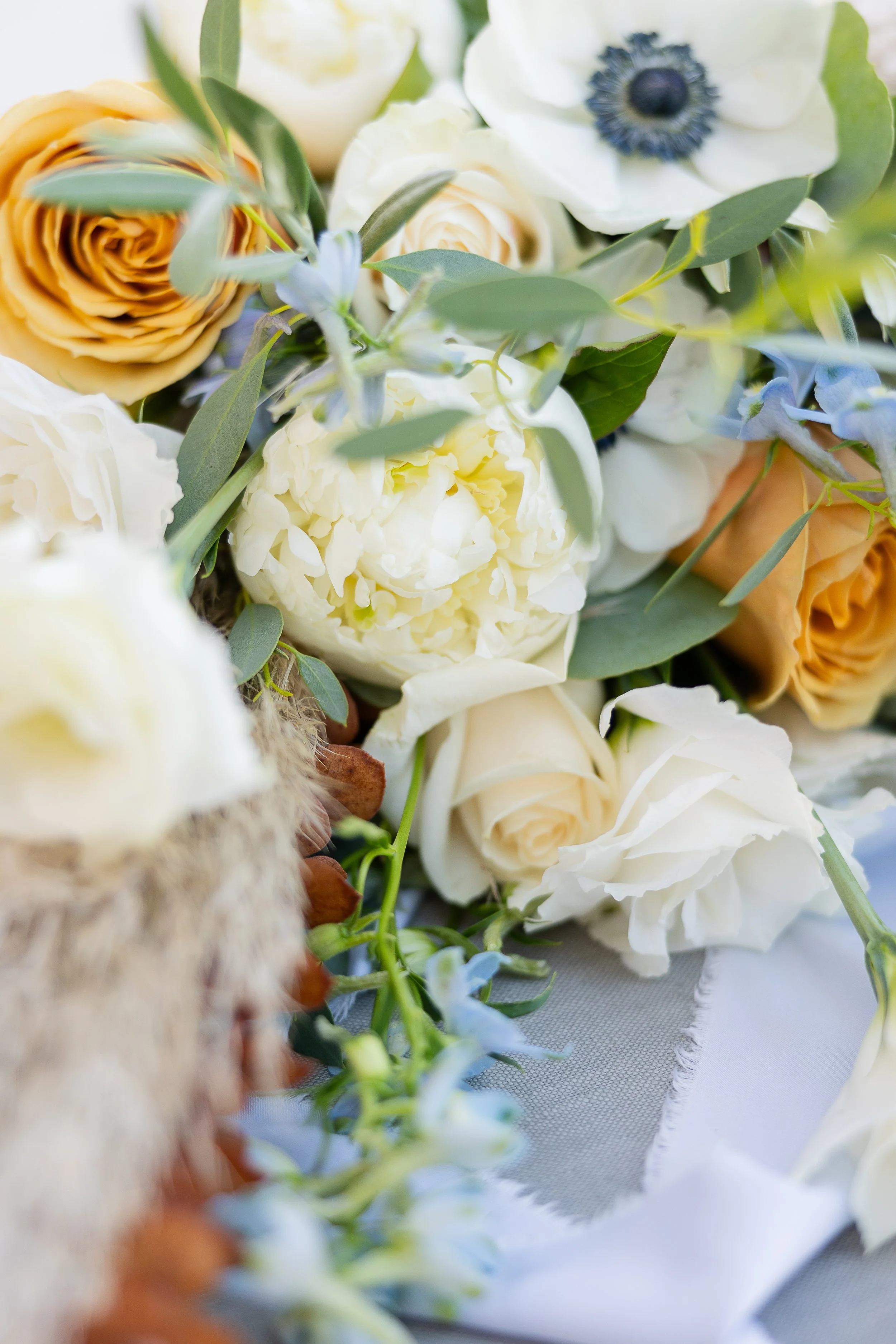 up close of bridal bouquet with toffee roses, anemone, eucalyptus, and peonies, tuolumne county