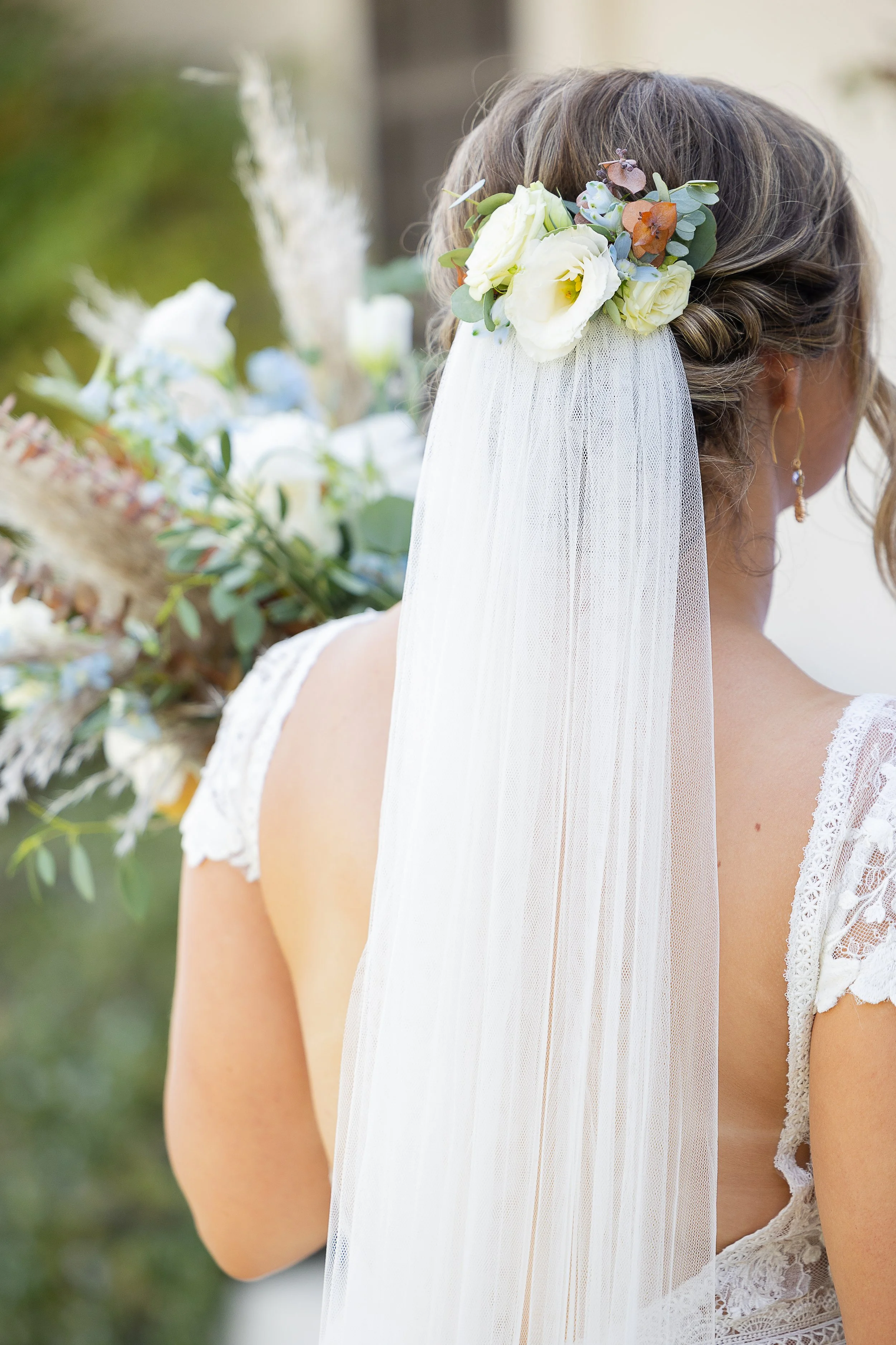 bride facing away from the camera hold bouquet showing off her hair peice made of lisianthus, roses, and eucalyptus, sincerely sonora florist