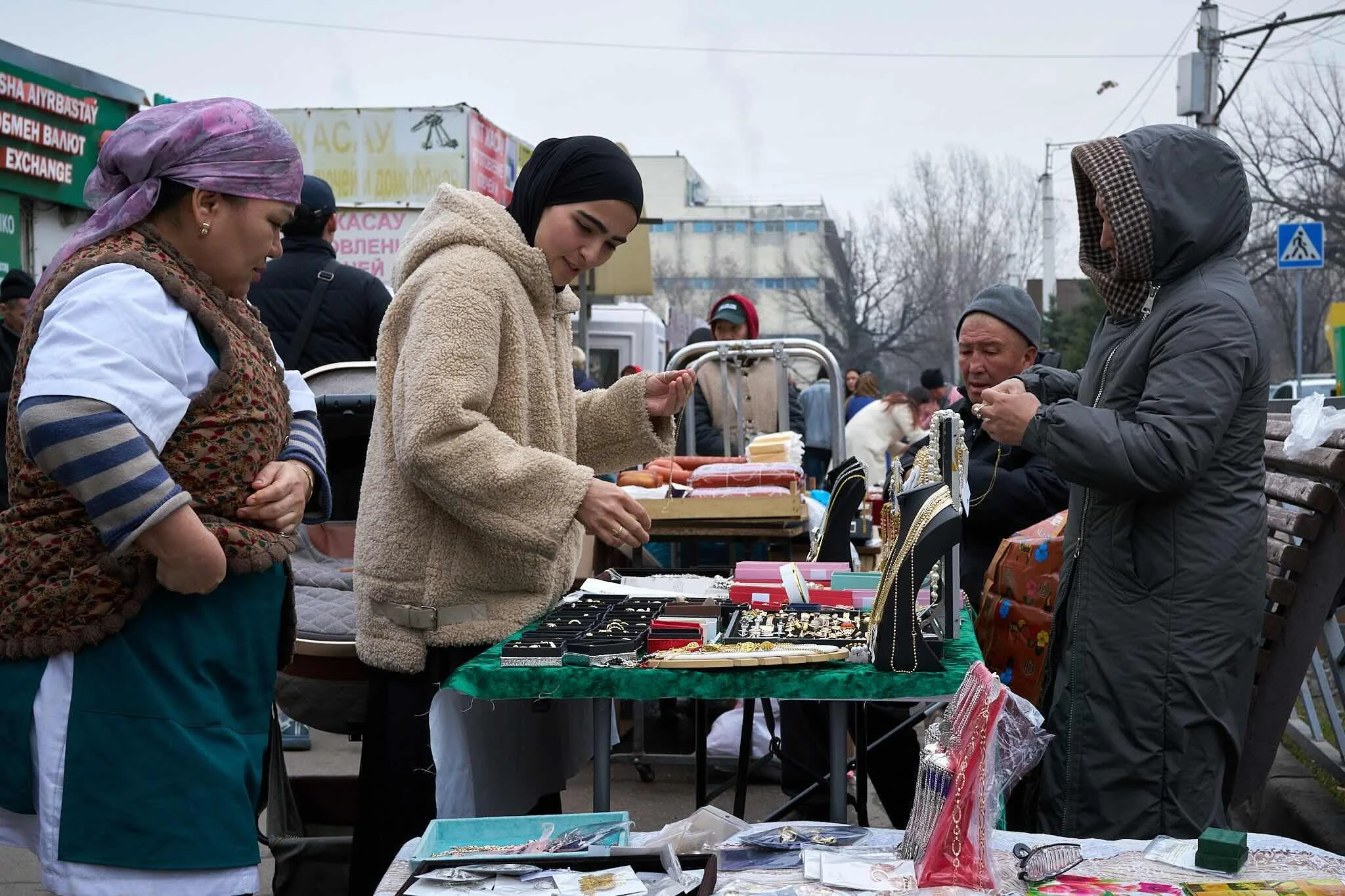 Jerzy Jaworek, Street and Travel Photography, Kazakhstan, Almaty. People shopping at an outdoor market, browsing jewelry and accessories displayed on tables.