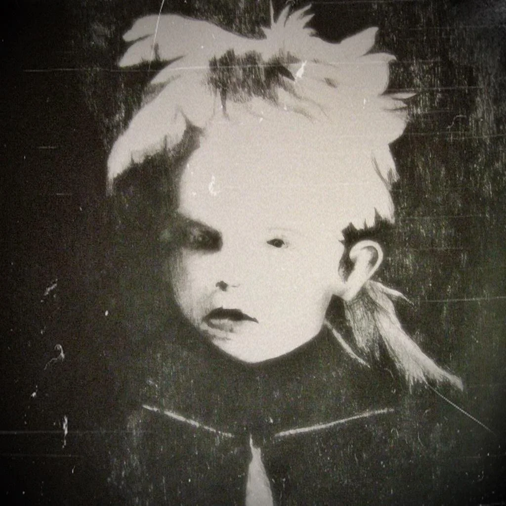 Black-and-white archival portrait photograph of Elsie Paroubek as a young child with light hair tied in bows, wearing a dark coat and staring directly at the camera.