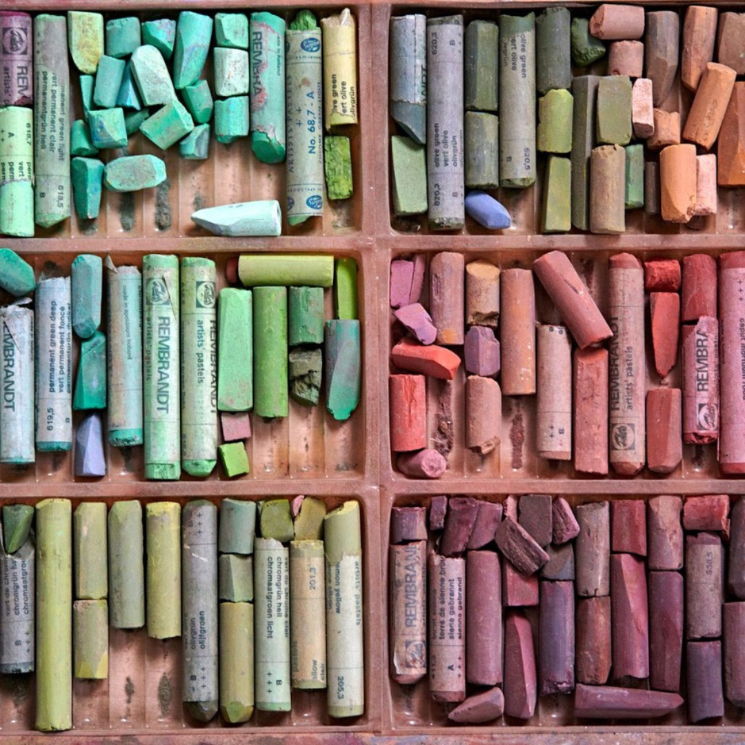 Assorted pastel chalks in various colors organized in a compartmentalized box.