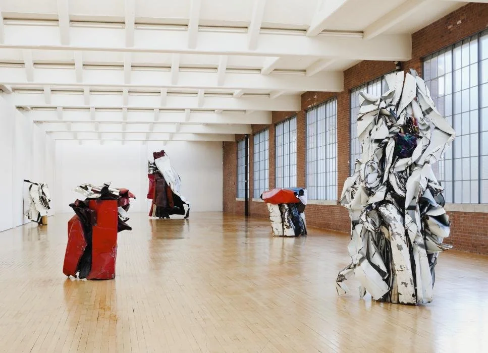 Installation view of monumental John Chamberlain sculptures at Dia Beacon, where crushed automobile steel becomes rhythmic, lyrical abstraction in expansive industrial gallery space.