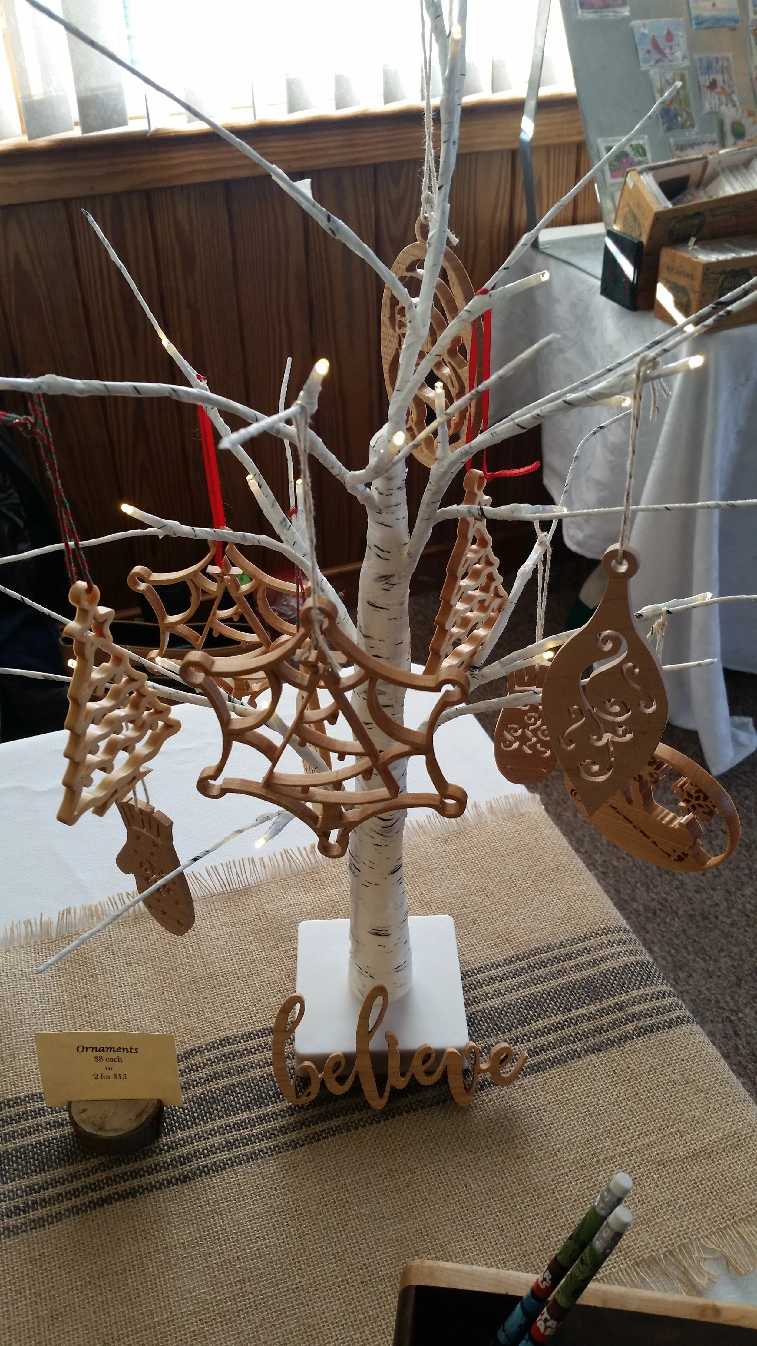 Craft fair display of some of my wooden ornaments. These are maple and cedar cut by hand on the scroll saw. Ornaments available online!