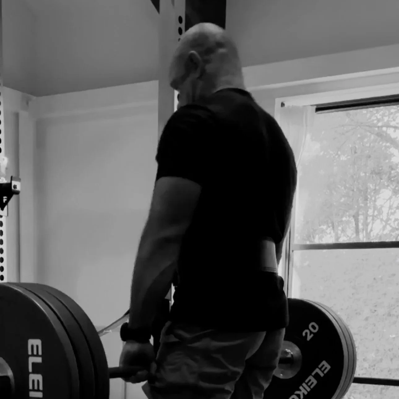 Close-up of hands applying massage or pressure on a person's torso, in black and white.