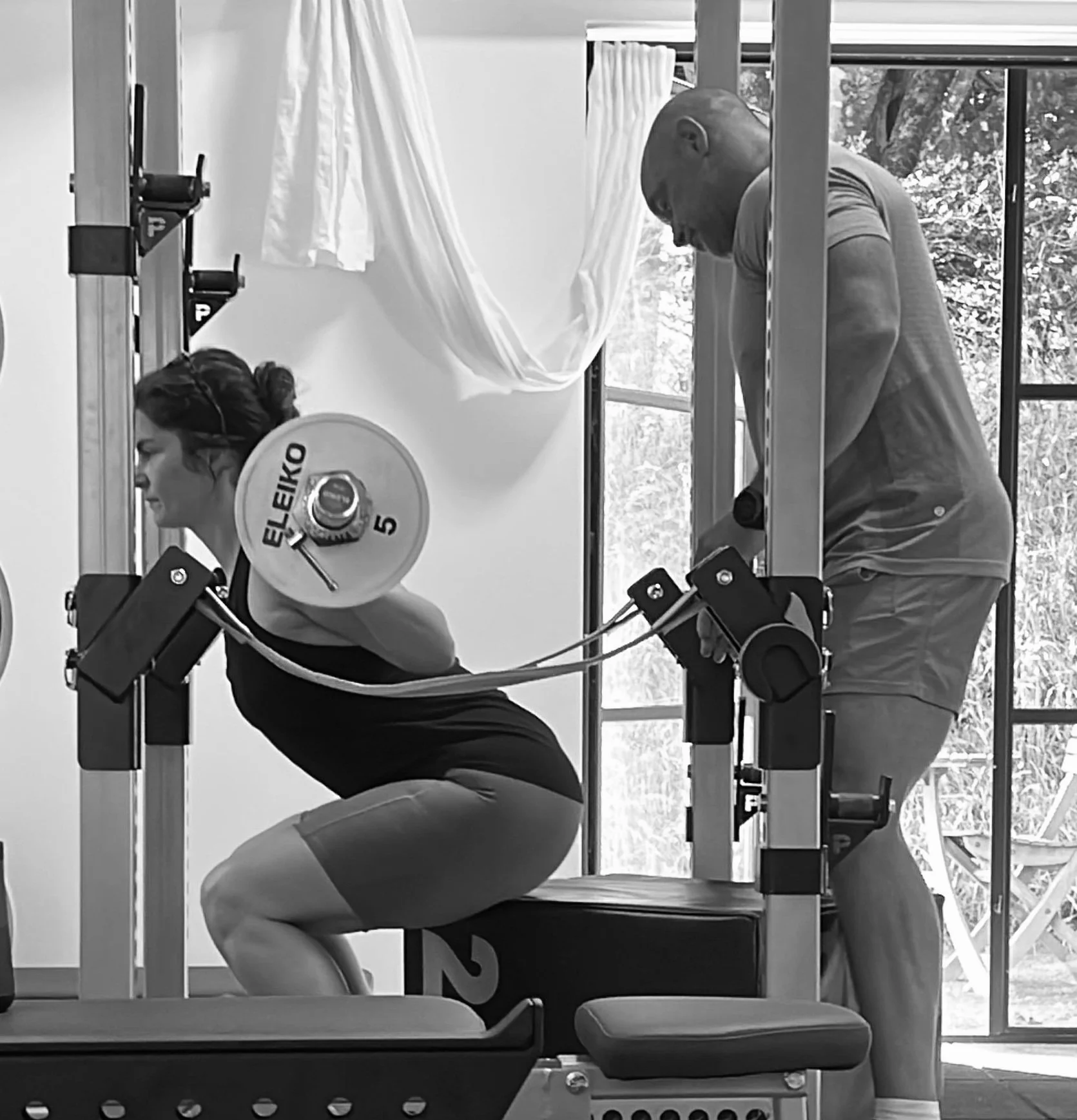 A person holding a soap bar with a towel, applying soap to another person's back.