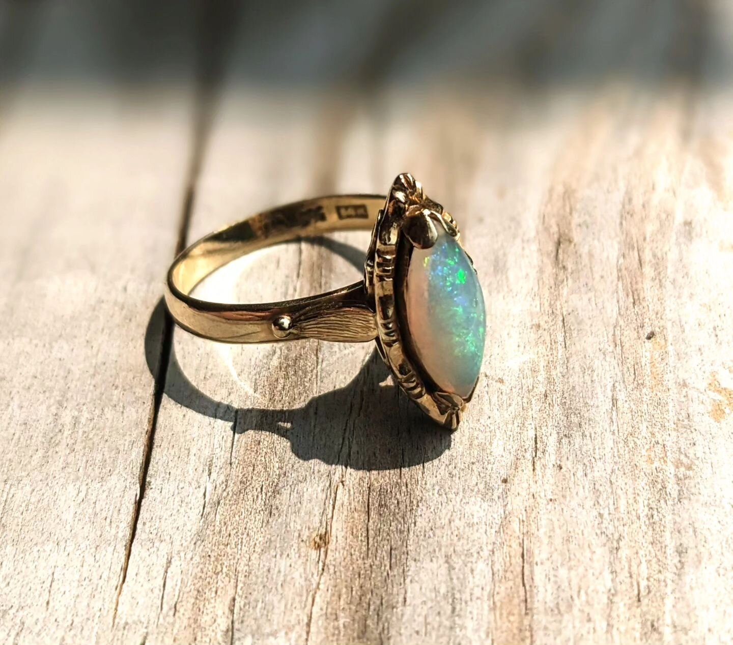 Brilliant, marquis-cut White Australian Opal set in ornate, 14k yellow gold! This antique stunner of a ring measures a US size 8 and will arrive in a burgundy velvet presentation box. Resizing available upon request. Perfect to use as an alternative 