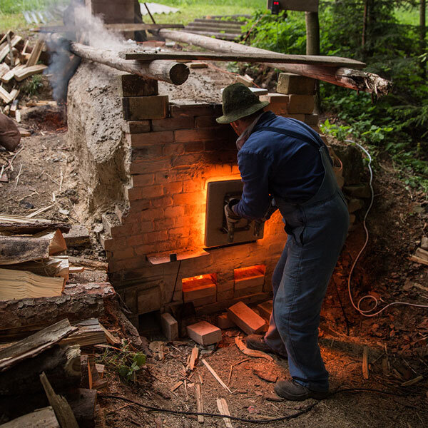 Josef Wiesner firing up his wood stove.