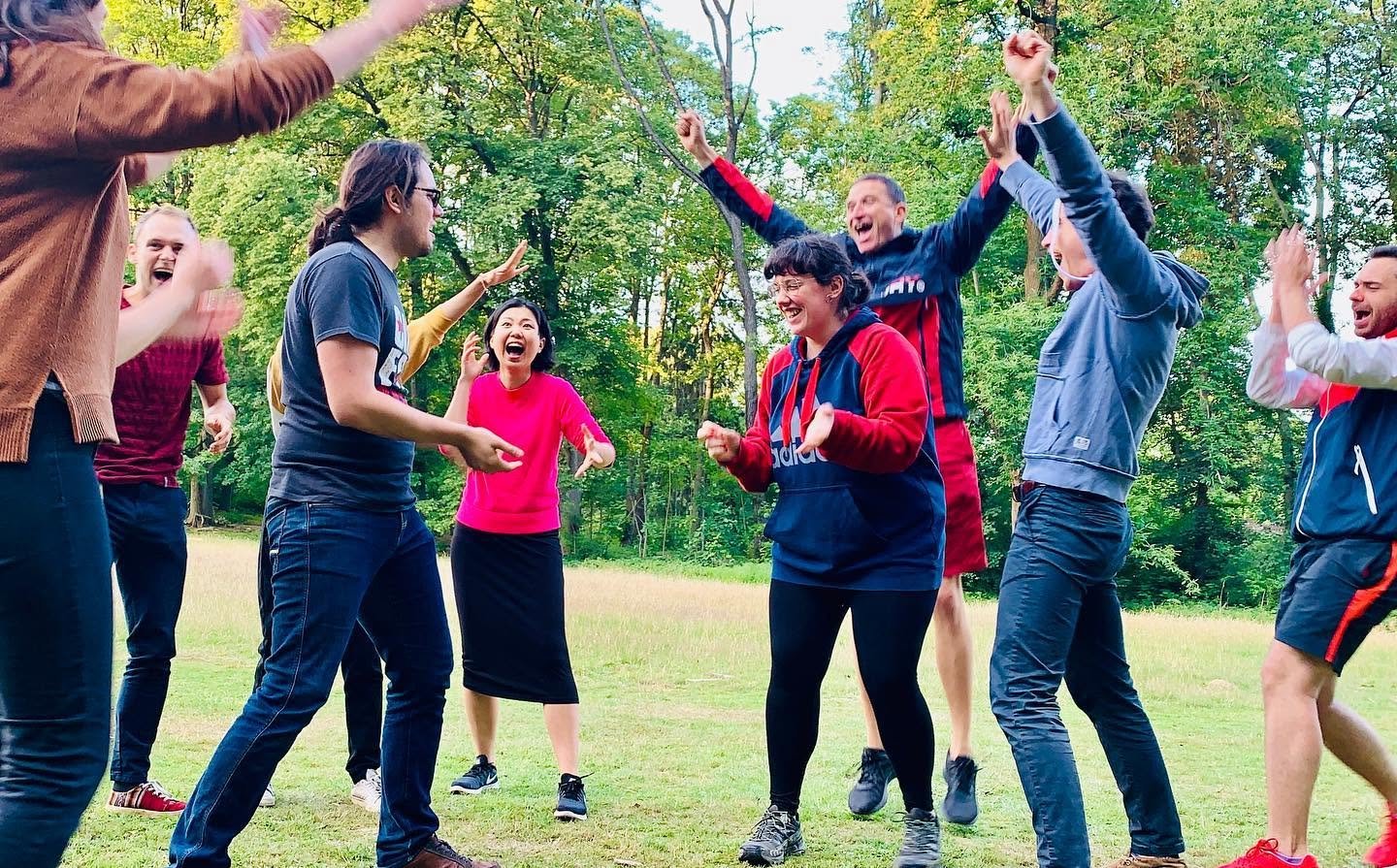 Women and men smiling and laughing playing improv in the parc