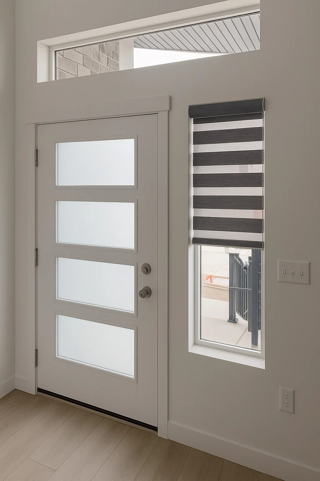 Interior view of a white door with four frosted glass panels and a modern stripe-patterned window blind on the right side, with partial outside view, white walls, and light-colored flooring.