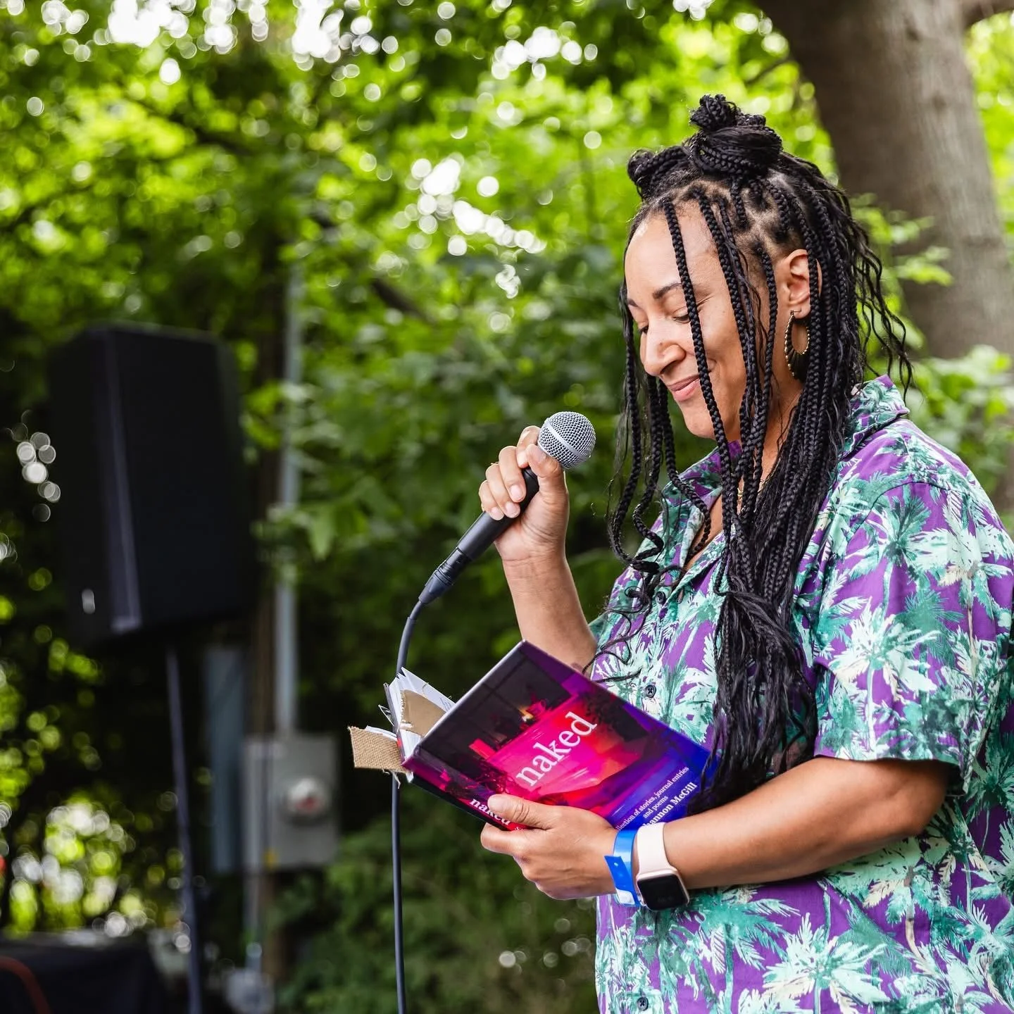 Shannon McGill-Hensley performing poetry from her book Naked at an outdoor literary event.