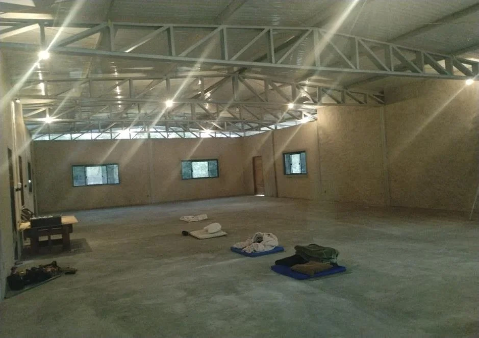 Inside the finished Dhamma hall, 200 square meters and four meters high, with windows sized for cross ventilation and dimmable light.