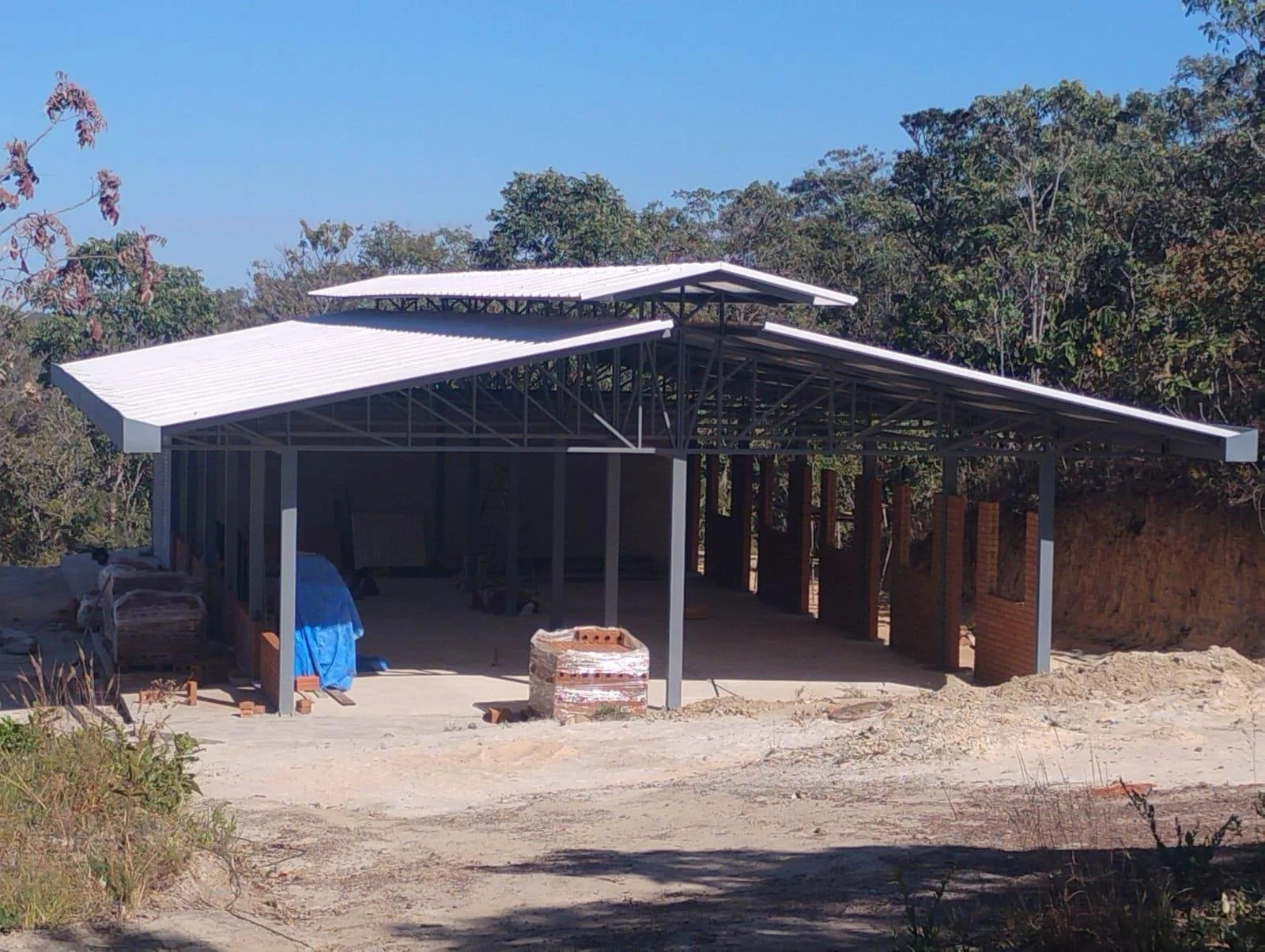 A dormitory block with its steel structure and thermoacoustic roofing in place, walls under way.
