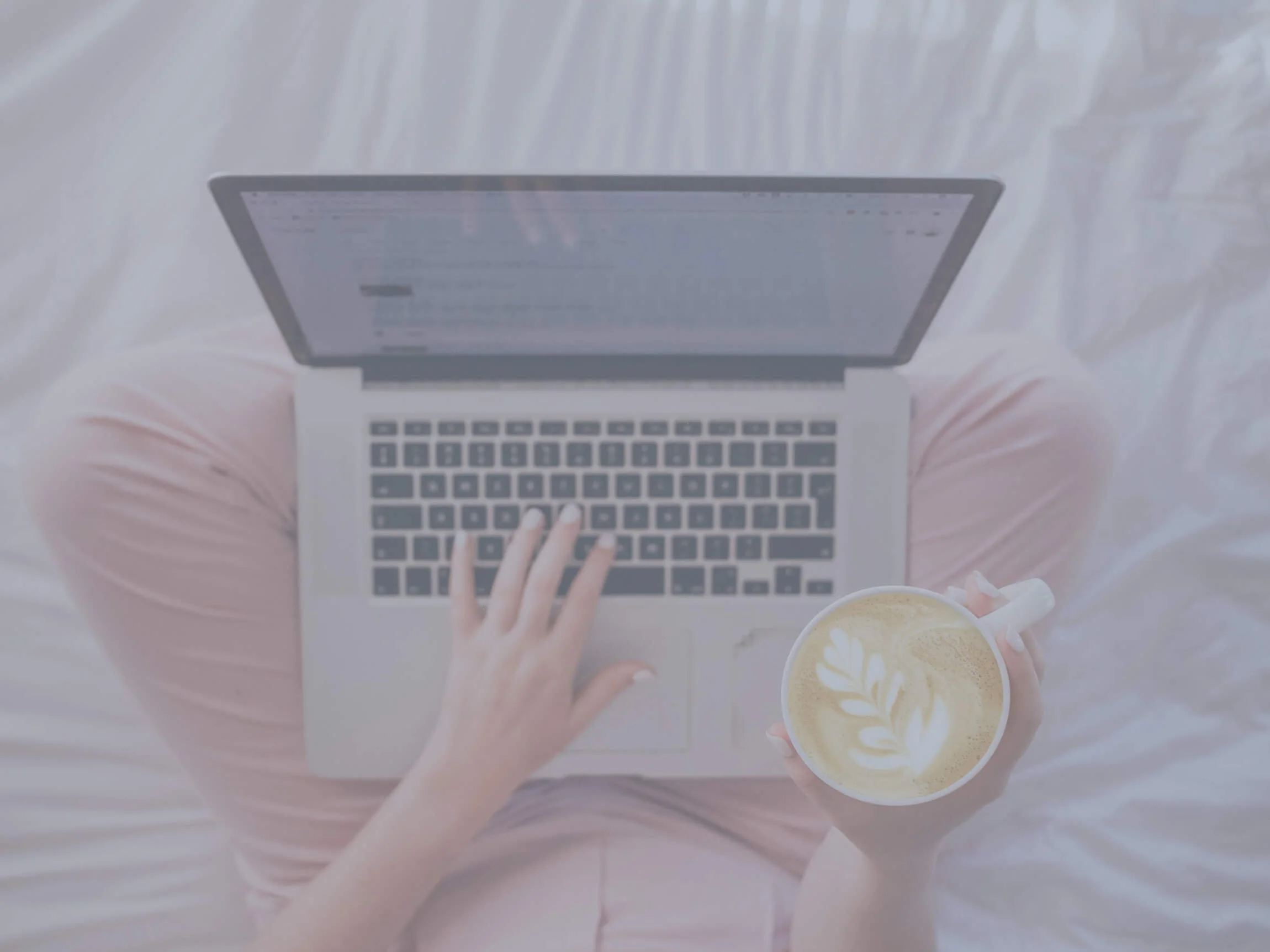 Woman reading blog in bed with a cappuccino copy.jpg