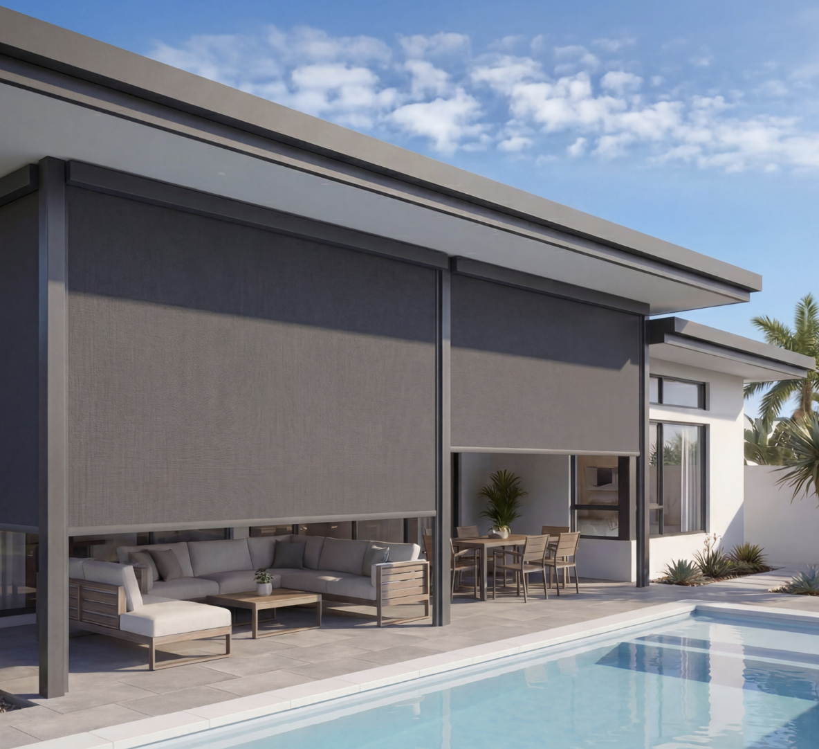 Modern house with an outdoor patio, pool, and furniture, including a sofa, dining table, and chairs, under a blue sky with fluffy clouds and palm trees in the background.