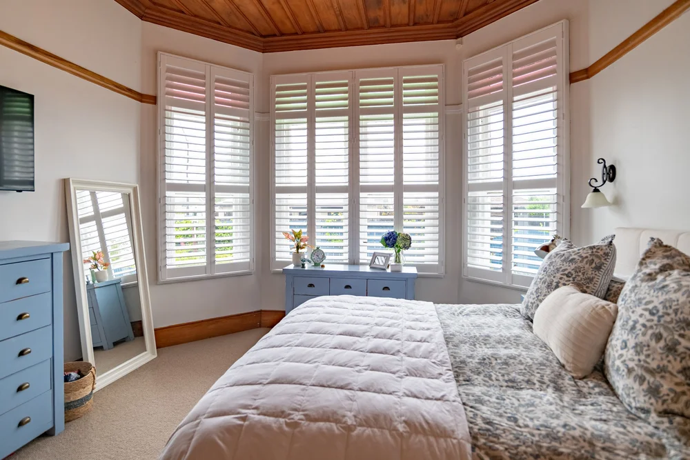 White shutters in the bay bedroom window of a villa