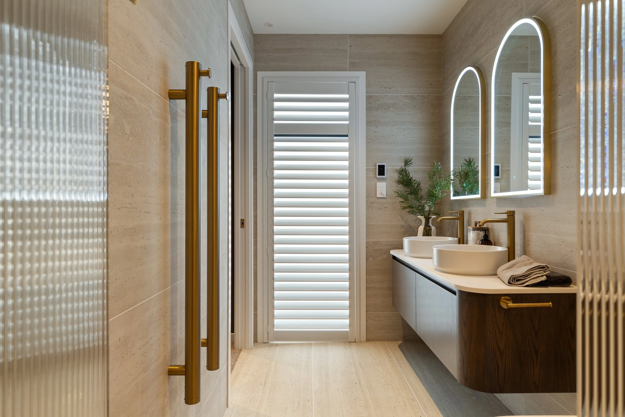 Tall window with a white plantation shutter in a bathroom