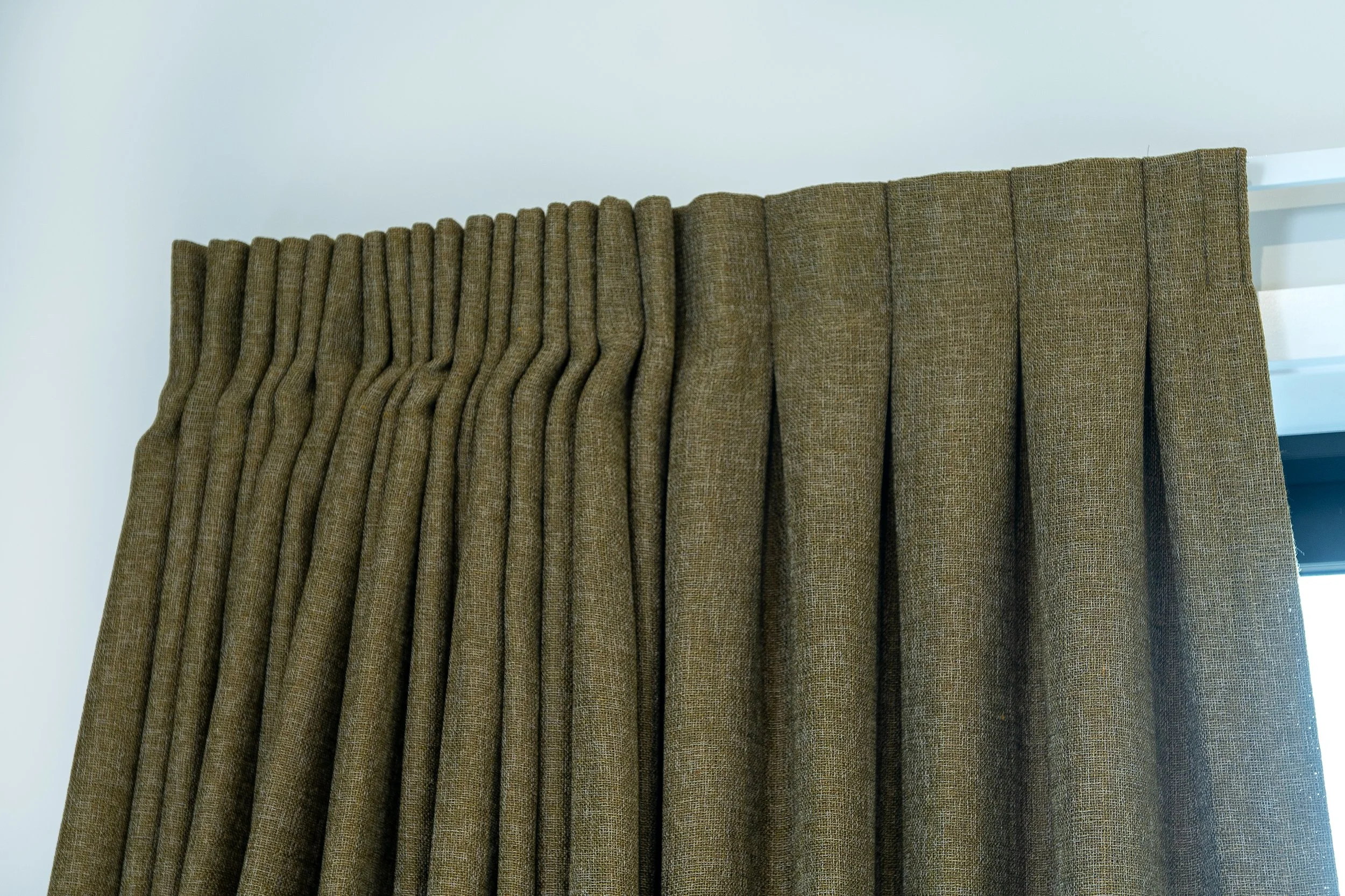 Brown textured curtains hanging from a curtain rod