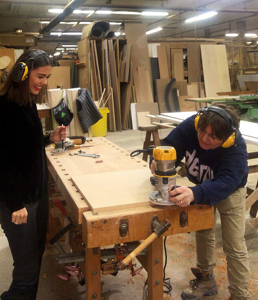 Quinn Hannum working with a millworker on a panel detail.