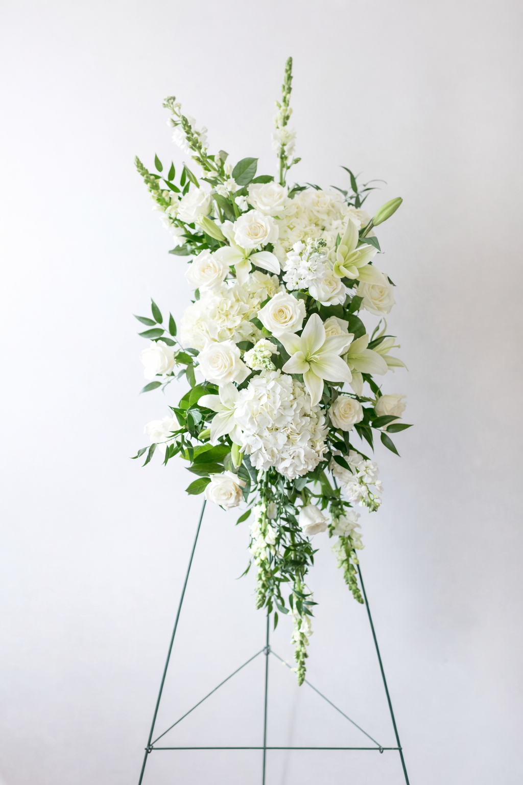 Elegant white floral centerpiece on easel.png