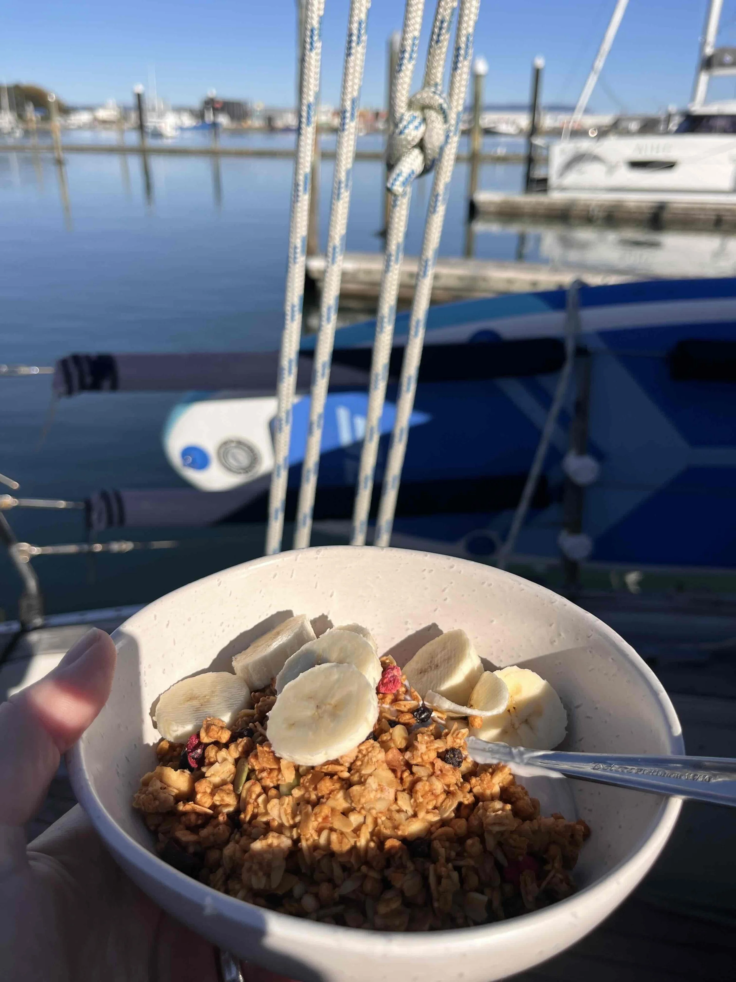Porridge, muslie and banana in a breakfast bowl onboard in the marina