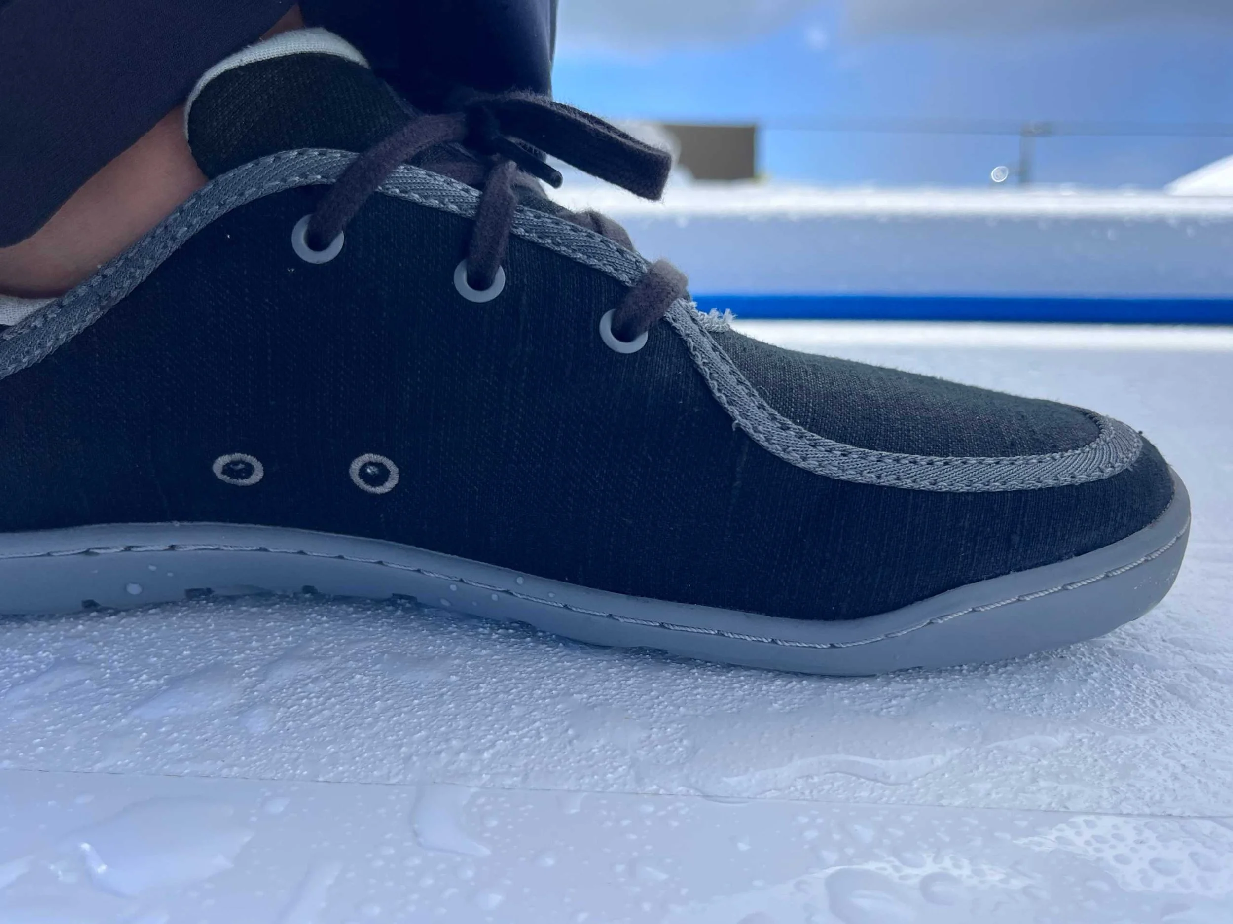 Close up of the Astral Loyak EZ HT being worn on a wet sailboat deck
