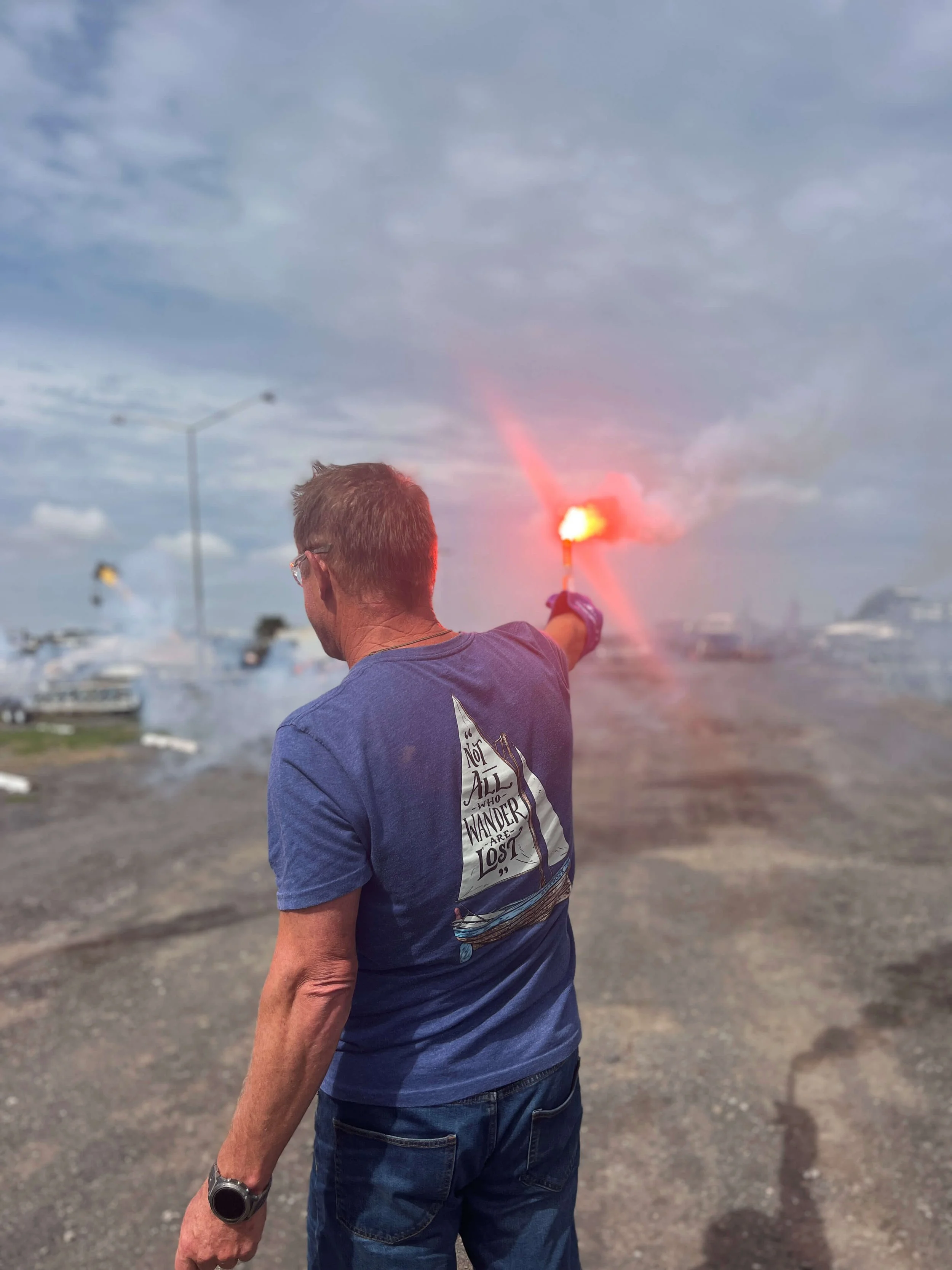 Sailor holding a red distress flare in demonstration