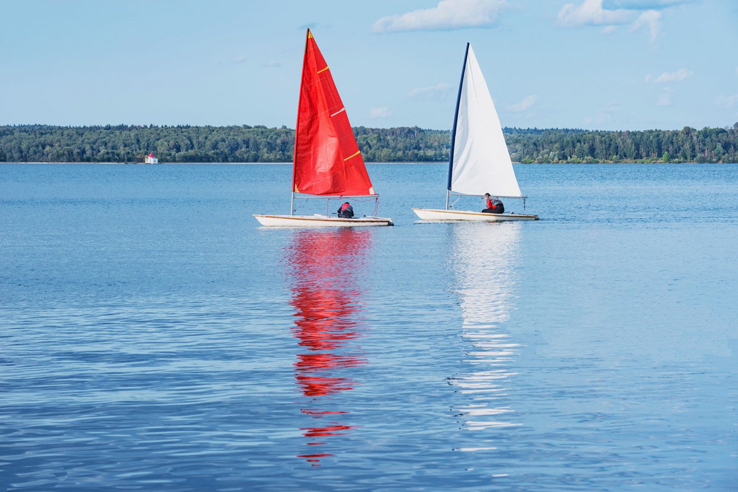 Two small sailboats cruising in calm water