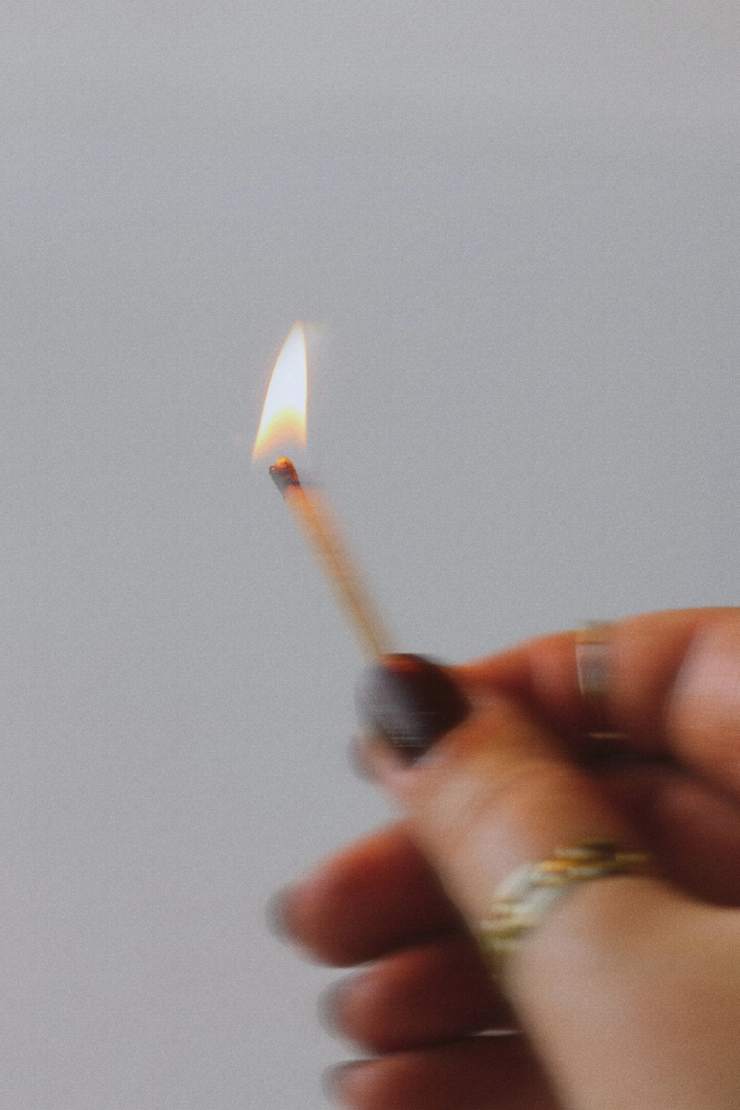 hand holding a lit match