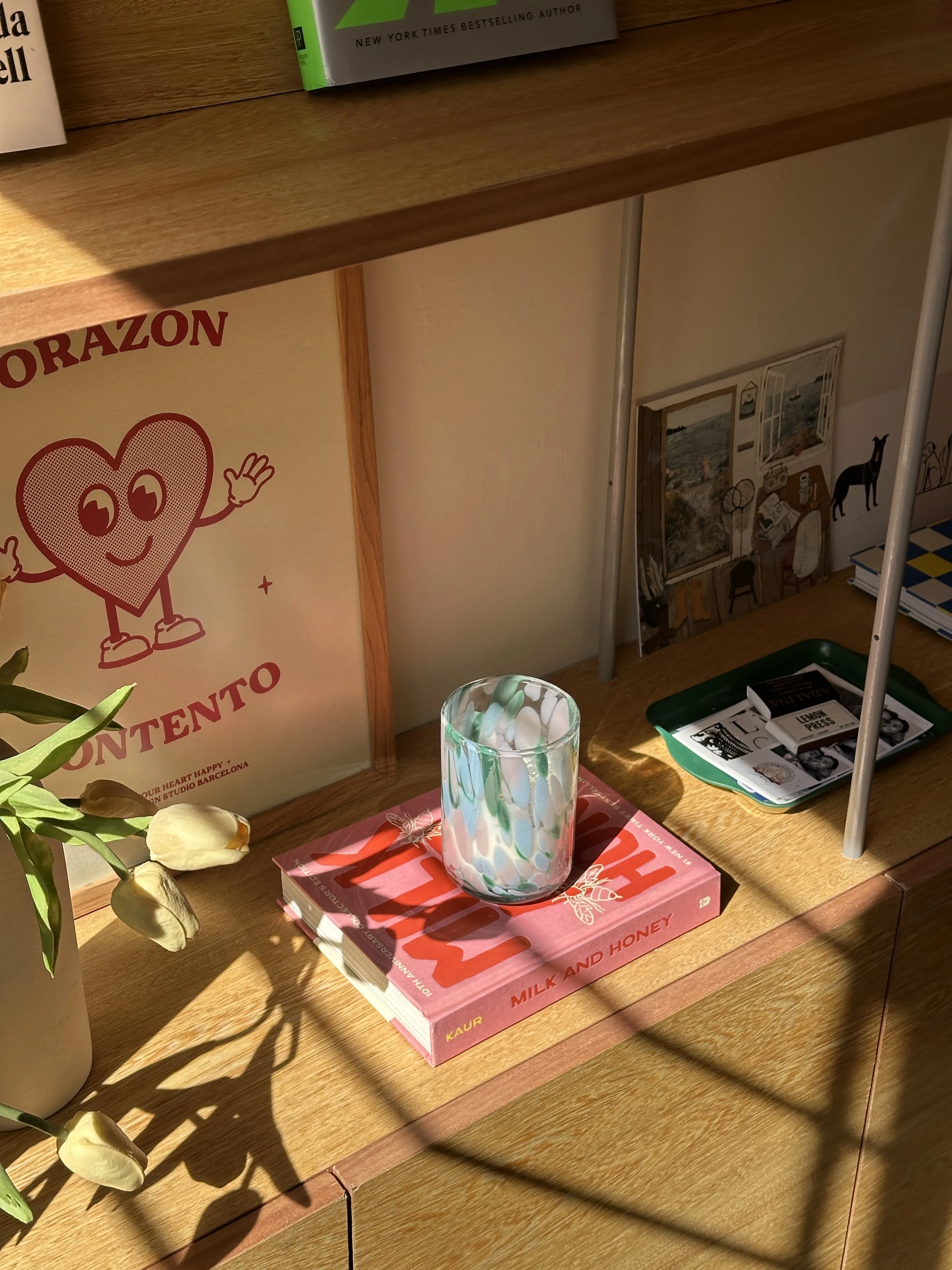 sunny shelf with books, plant, and candle