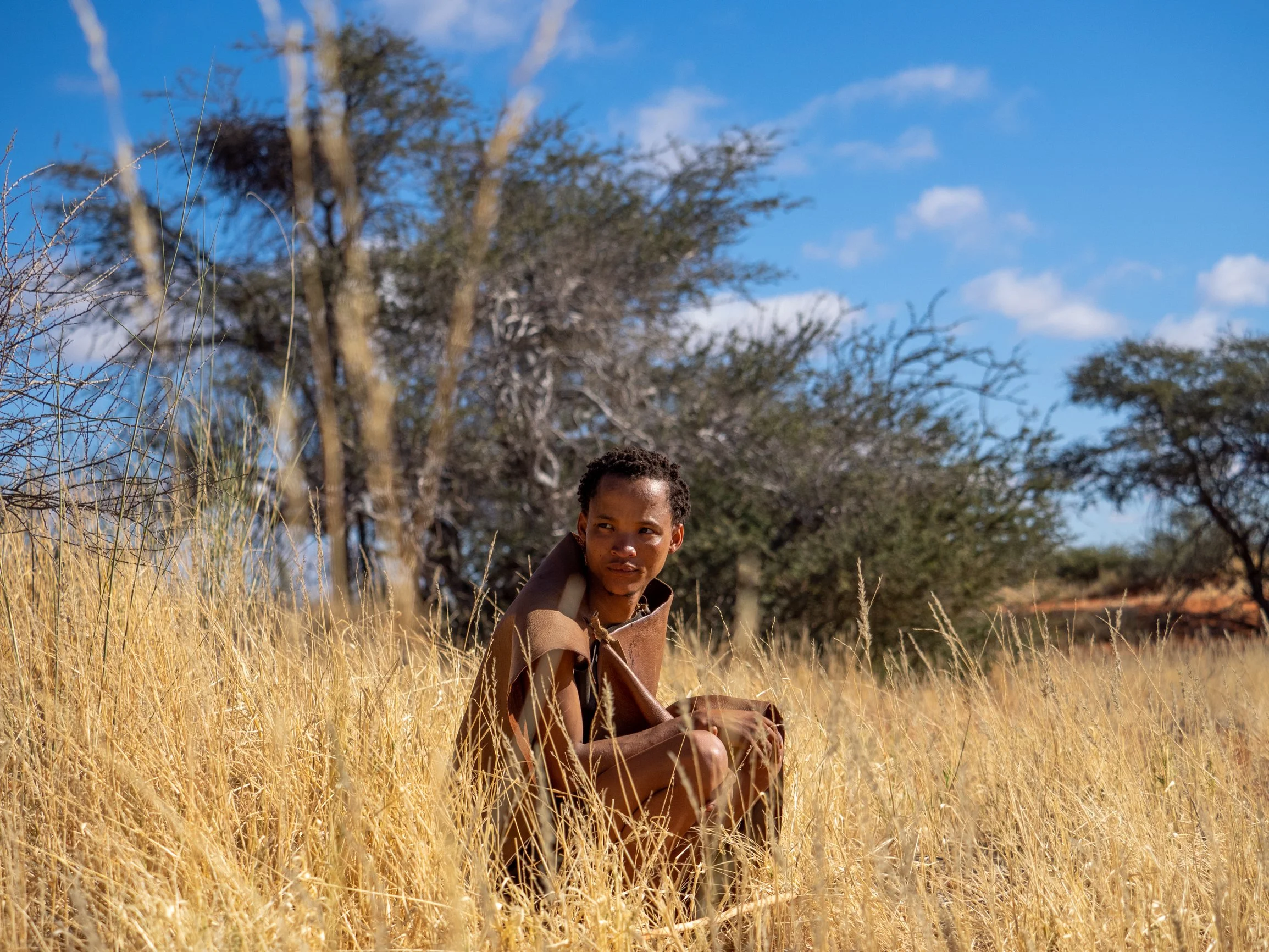 Namibian bushman crouching in the grass