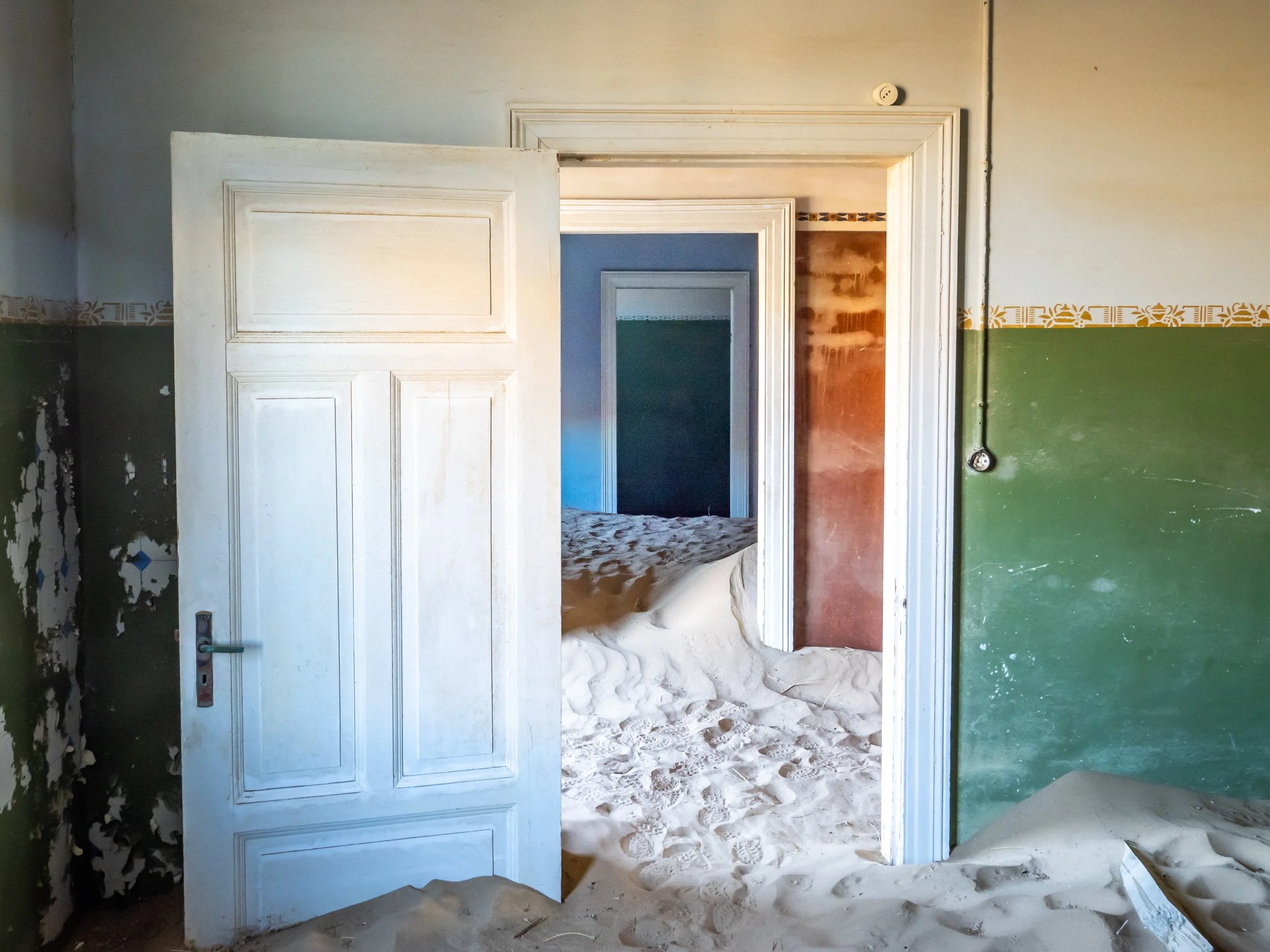 Sand spilling between doors in Kolmanskop