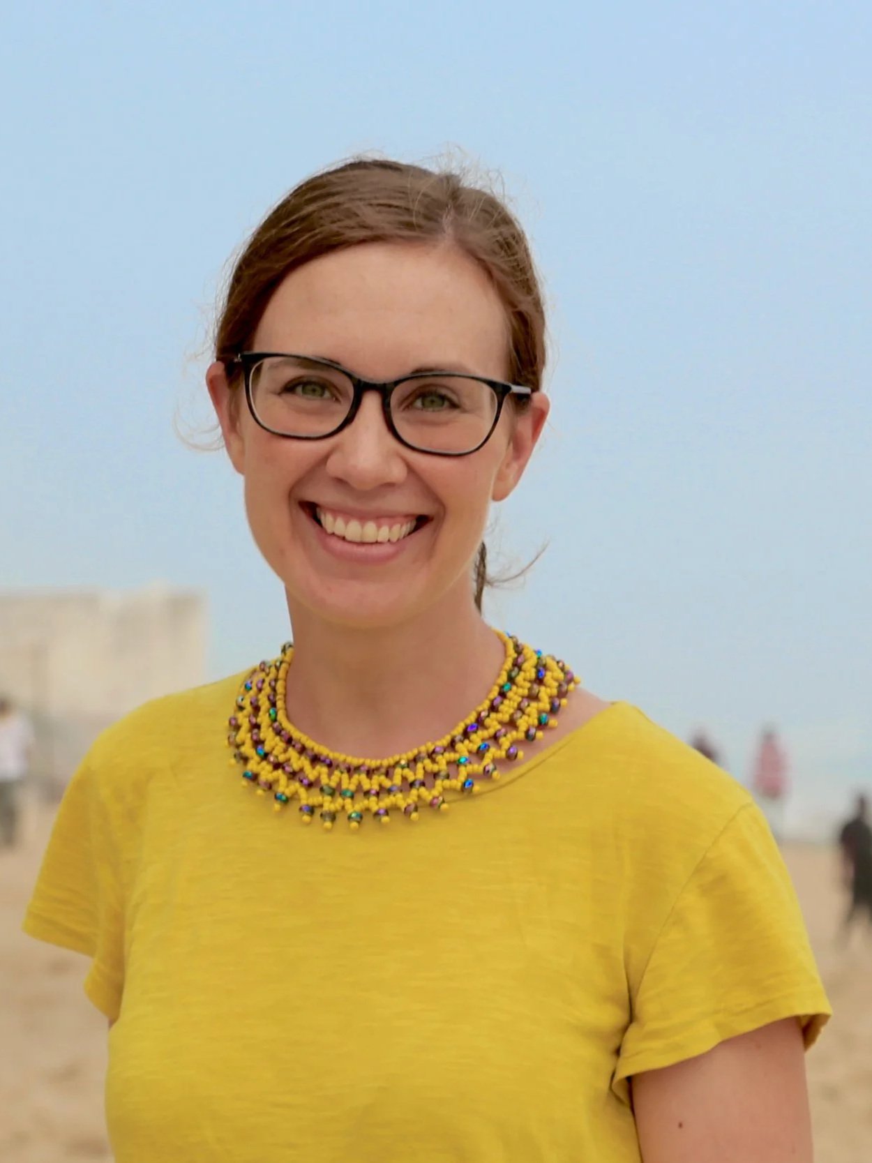 Portrait of a woman wearing glasses and a yellow blouse