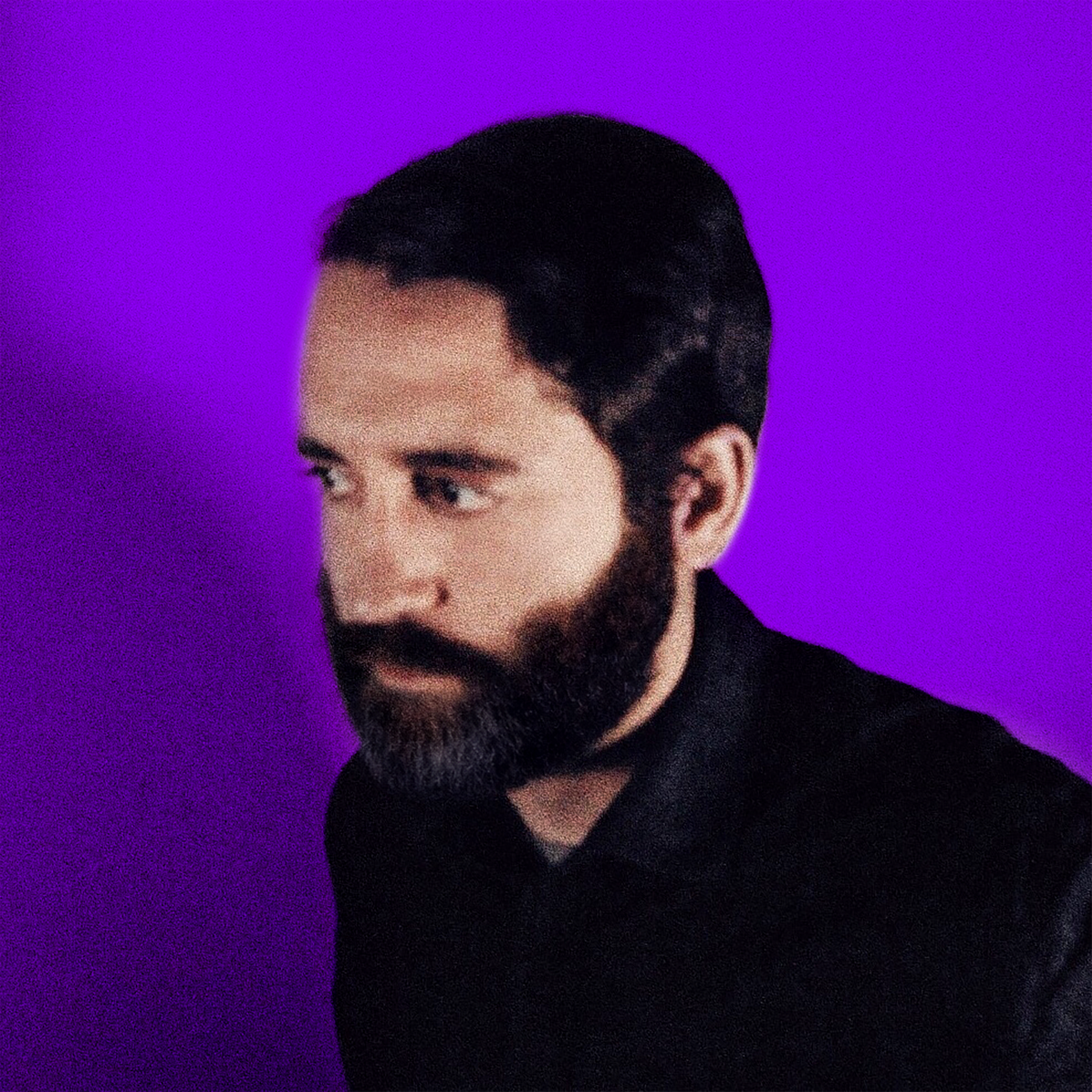 Portrait of Ryan Samanka, a man with dark hair and a beard, dressed in black, against a vibrant purple background.