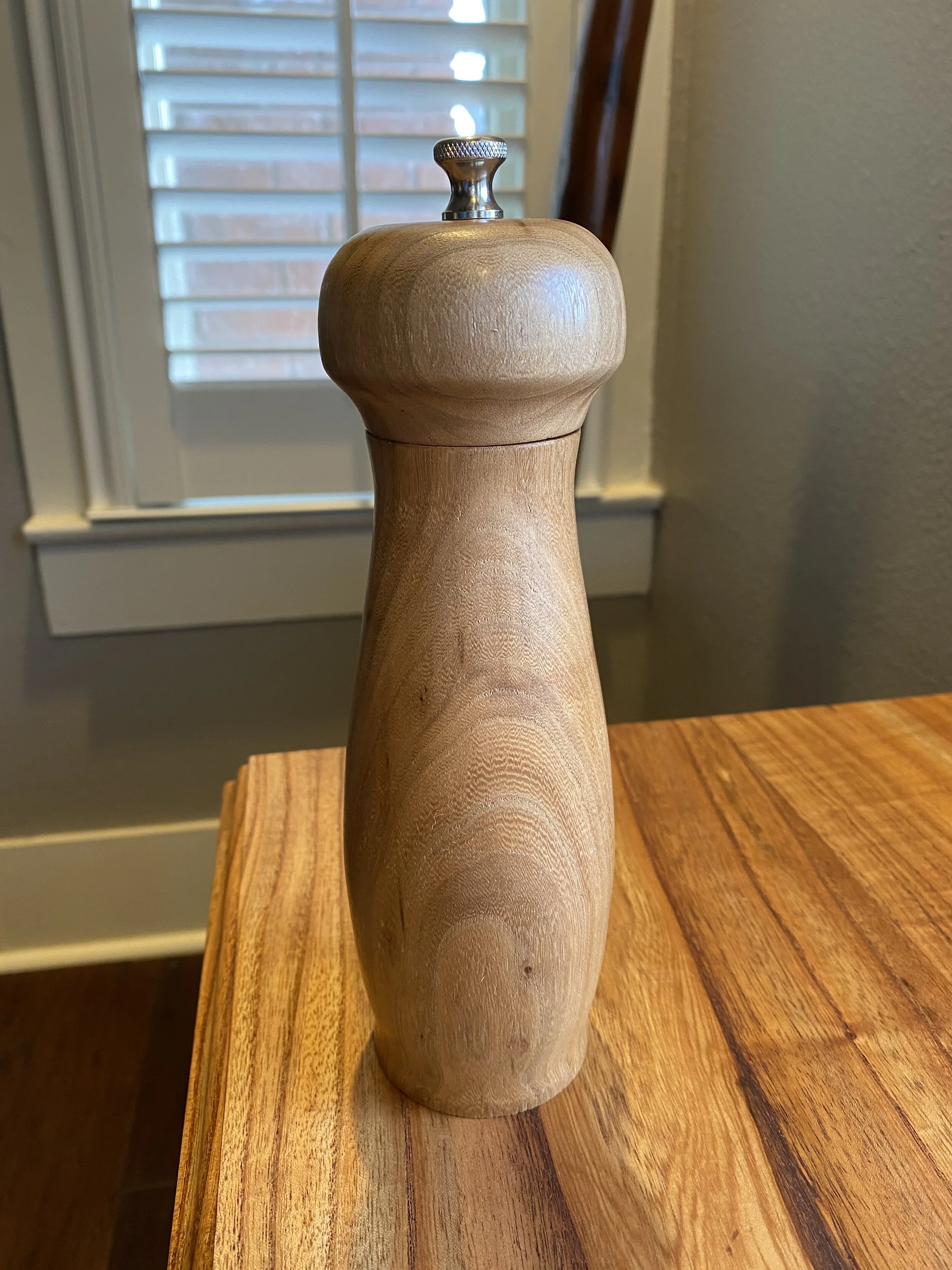 Hand-turned pepper mill made from Allen Cherry, smooth curved body with warm grain, crafted from Mr. Allen’s reclaimed boards.