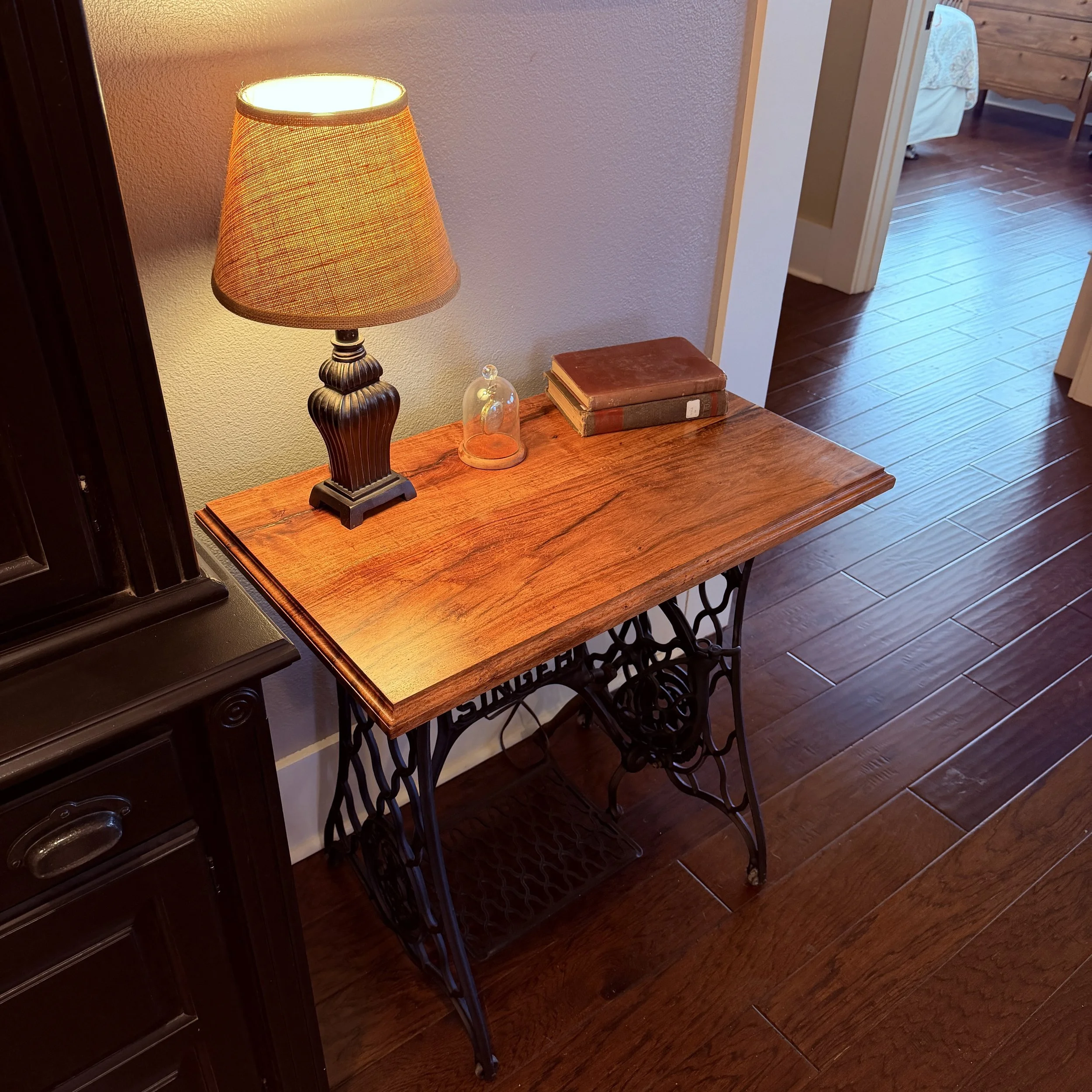 Angled view of Medina Mesquite lamp table on restored Singer treadle sewing machine base