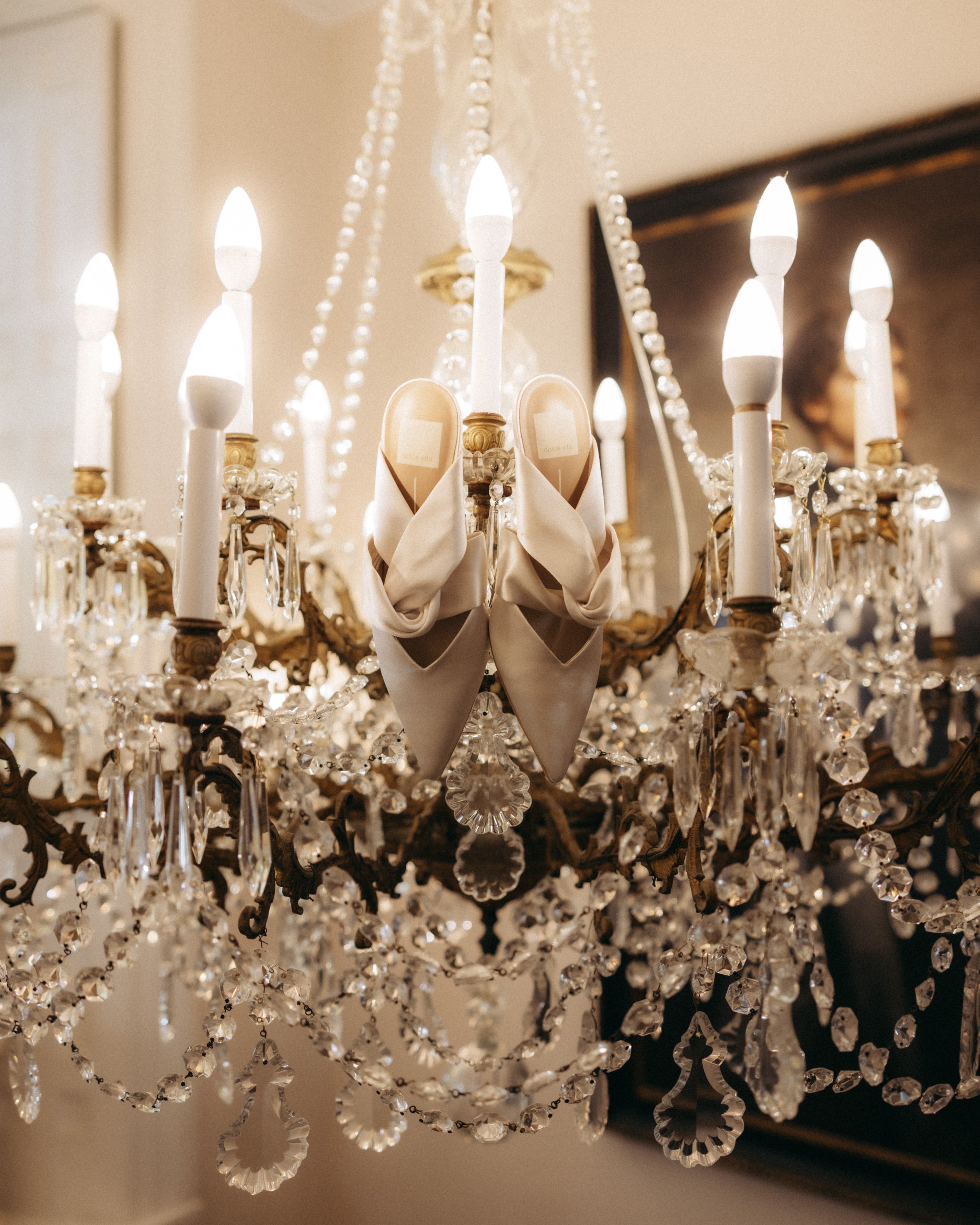 Close-up of a crystal chandelier with lit candle-shaped lights and hanging crystal decorations.